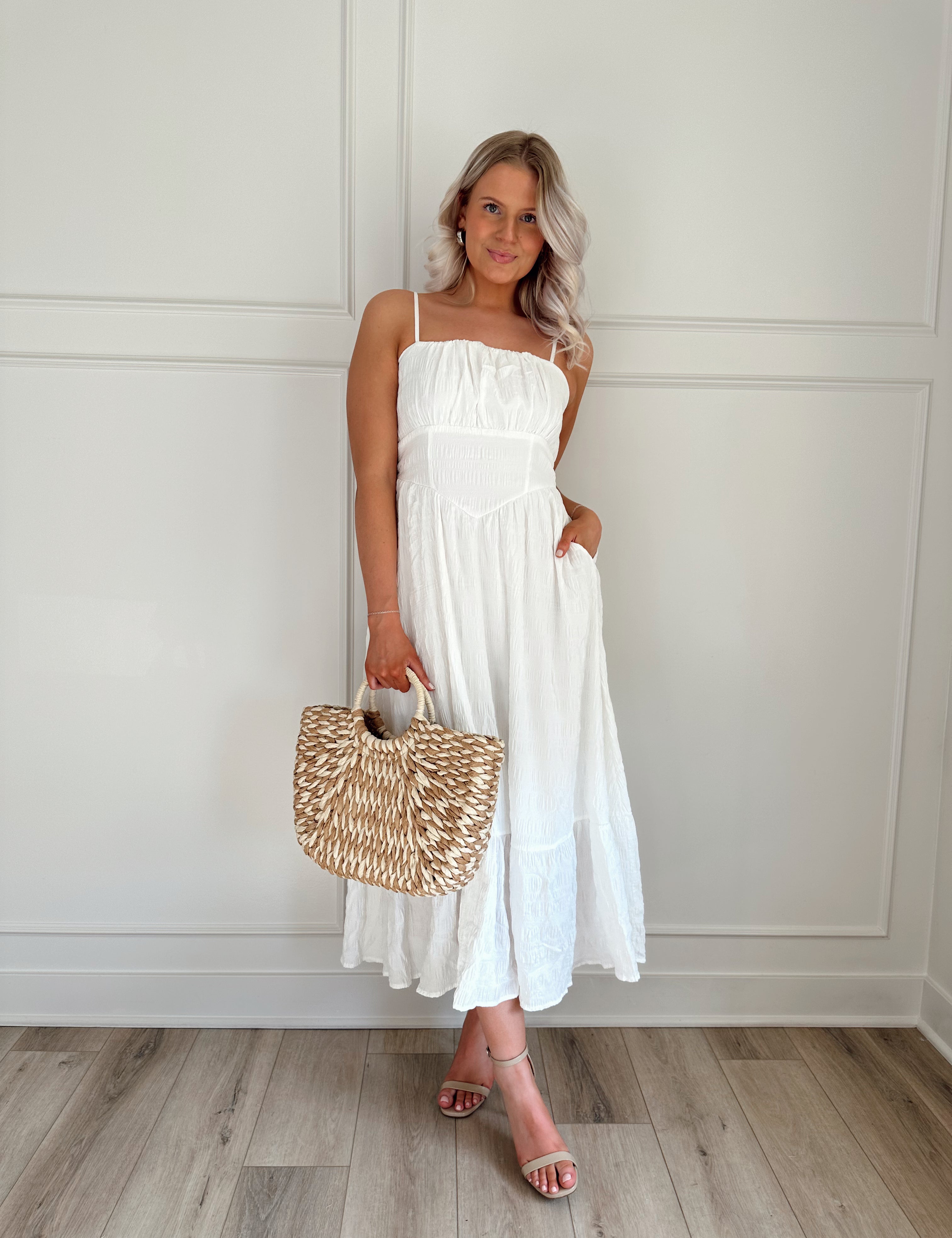 White textured midi dress with corset lining midsection and functional pockets.