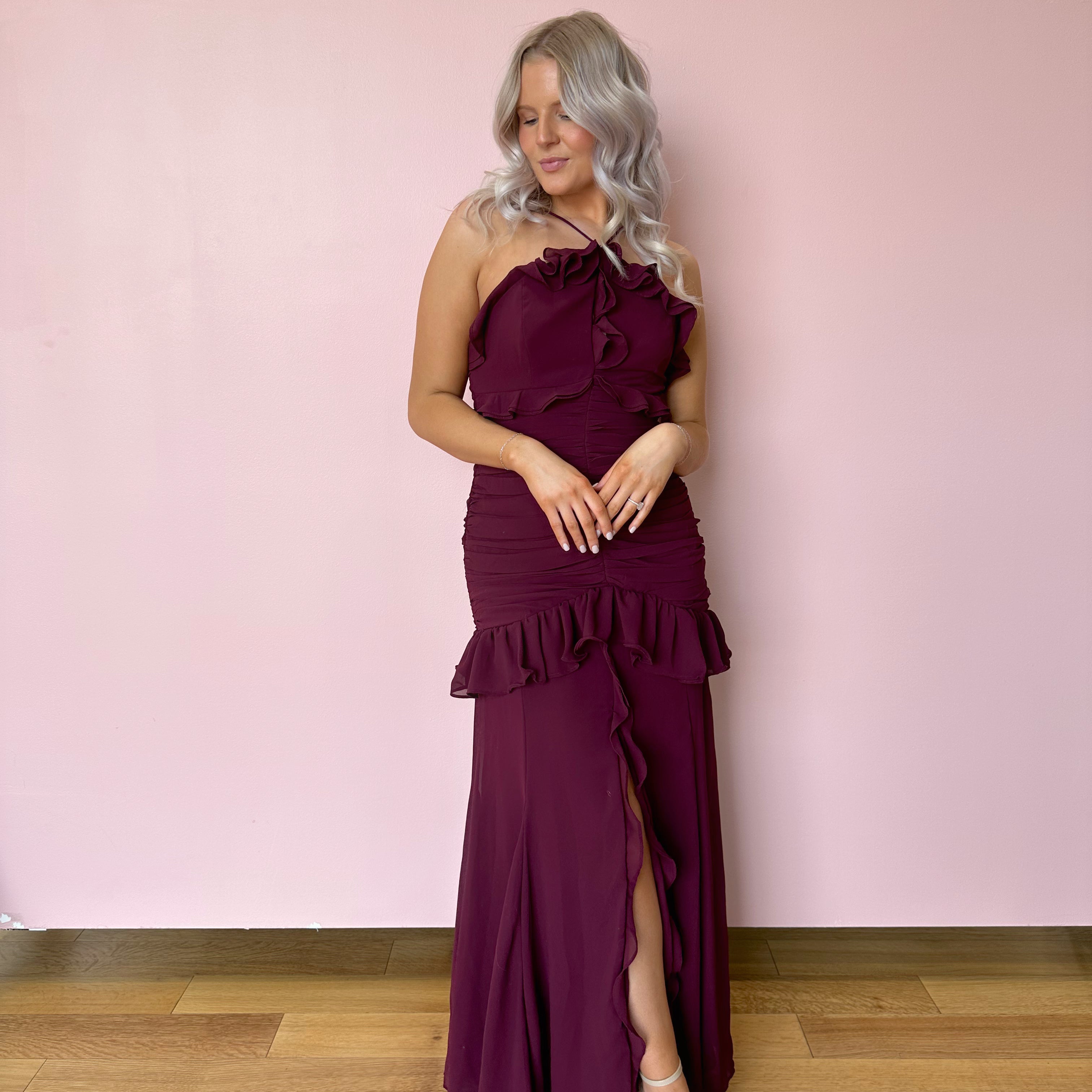 Burgundy formal maxi dress with ruffle detailing and slit up the front. 