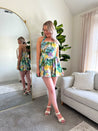 Green and purple tropical print mini dress with halter neckline.