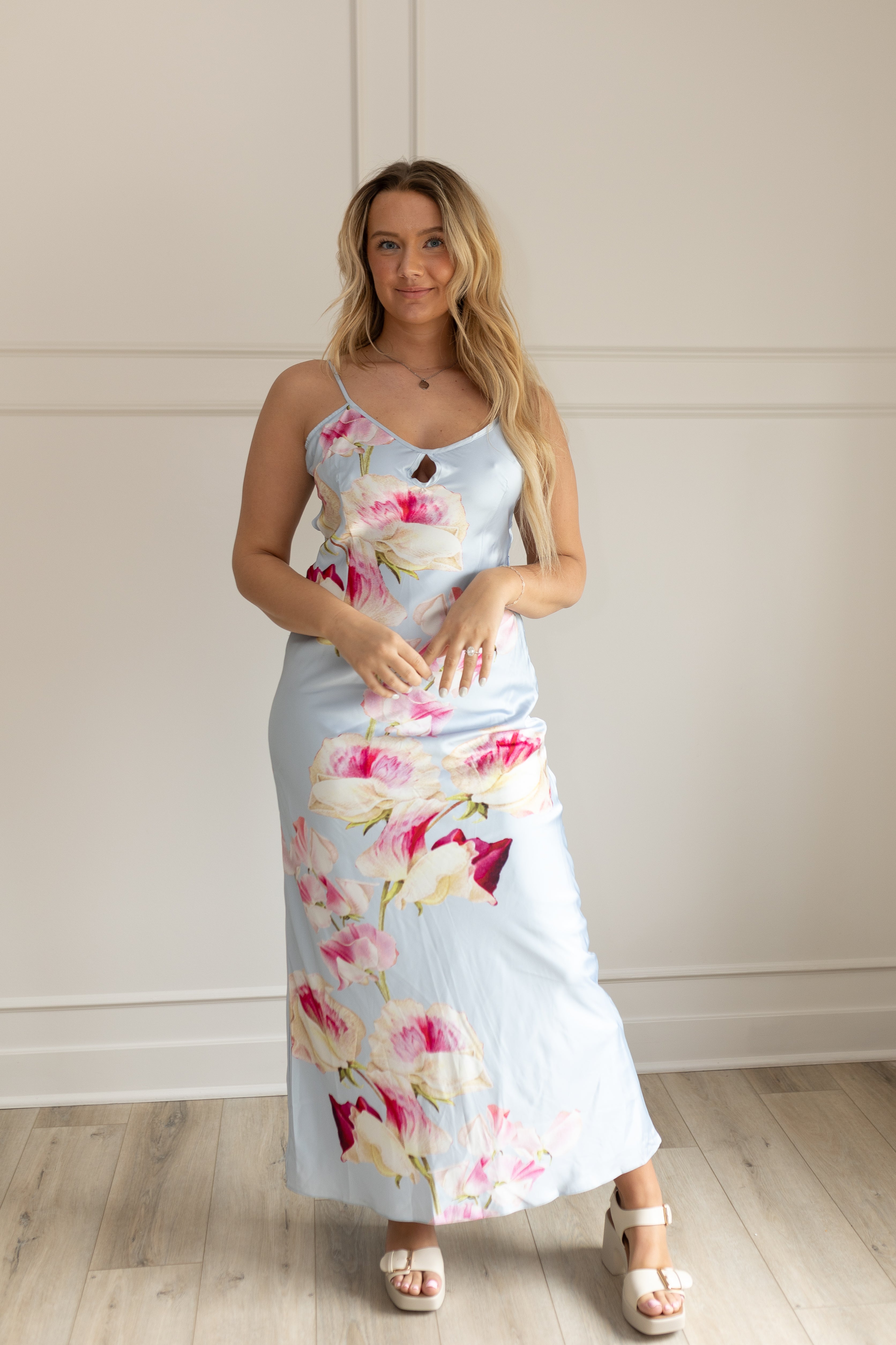 Blue satin maxi dress with pink floral pattern. Adjustable spaghetti straps and keyhole cutout. 