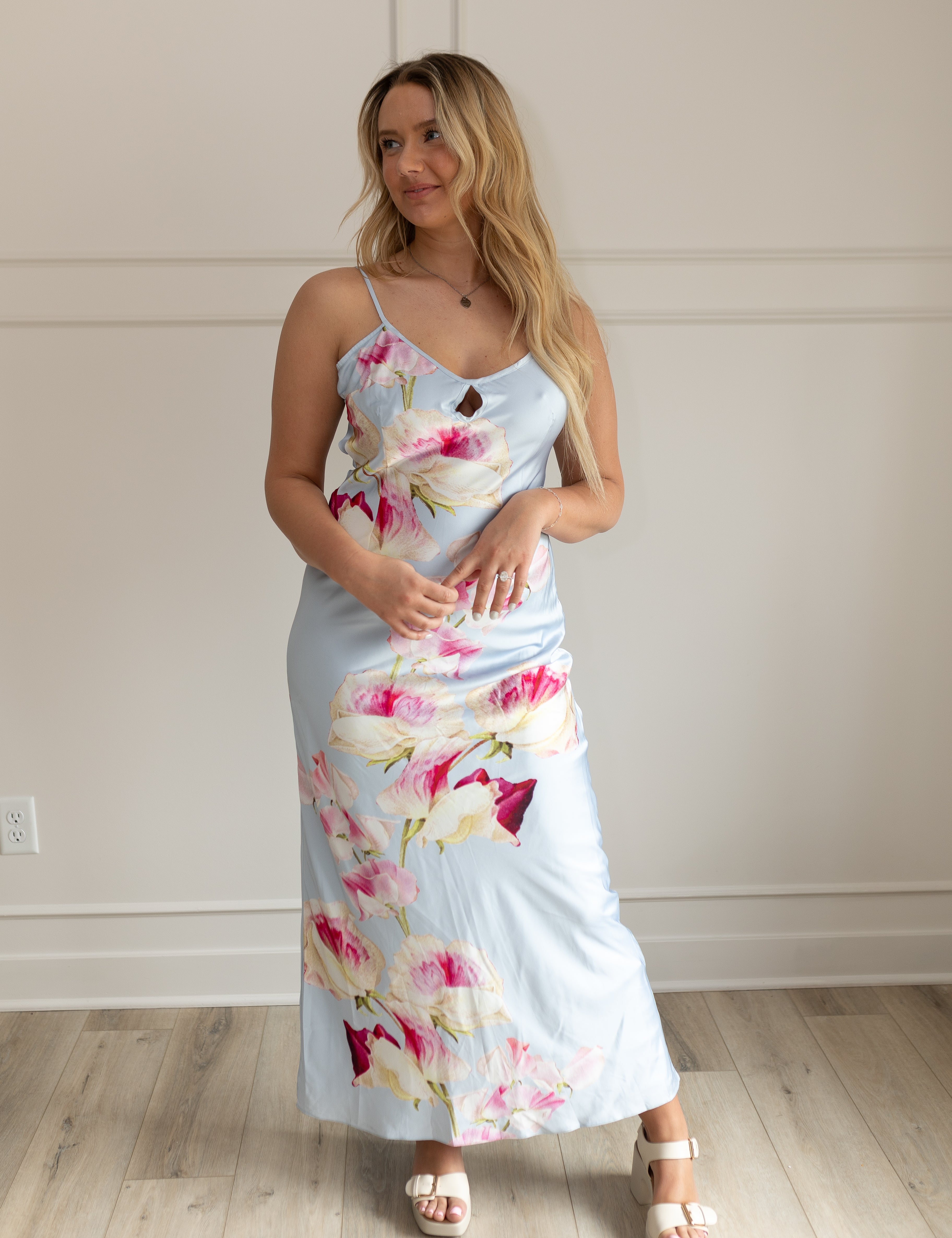 Blue satin maxi dress with pink floral pattern. Adjustable spaghetti straps and keyhole cutout. 