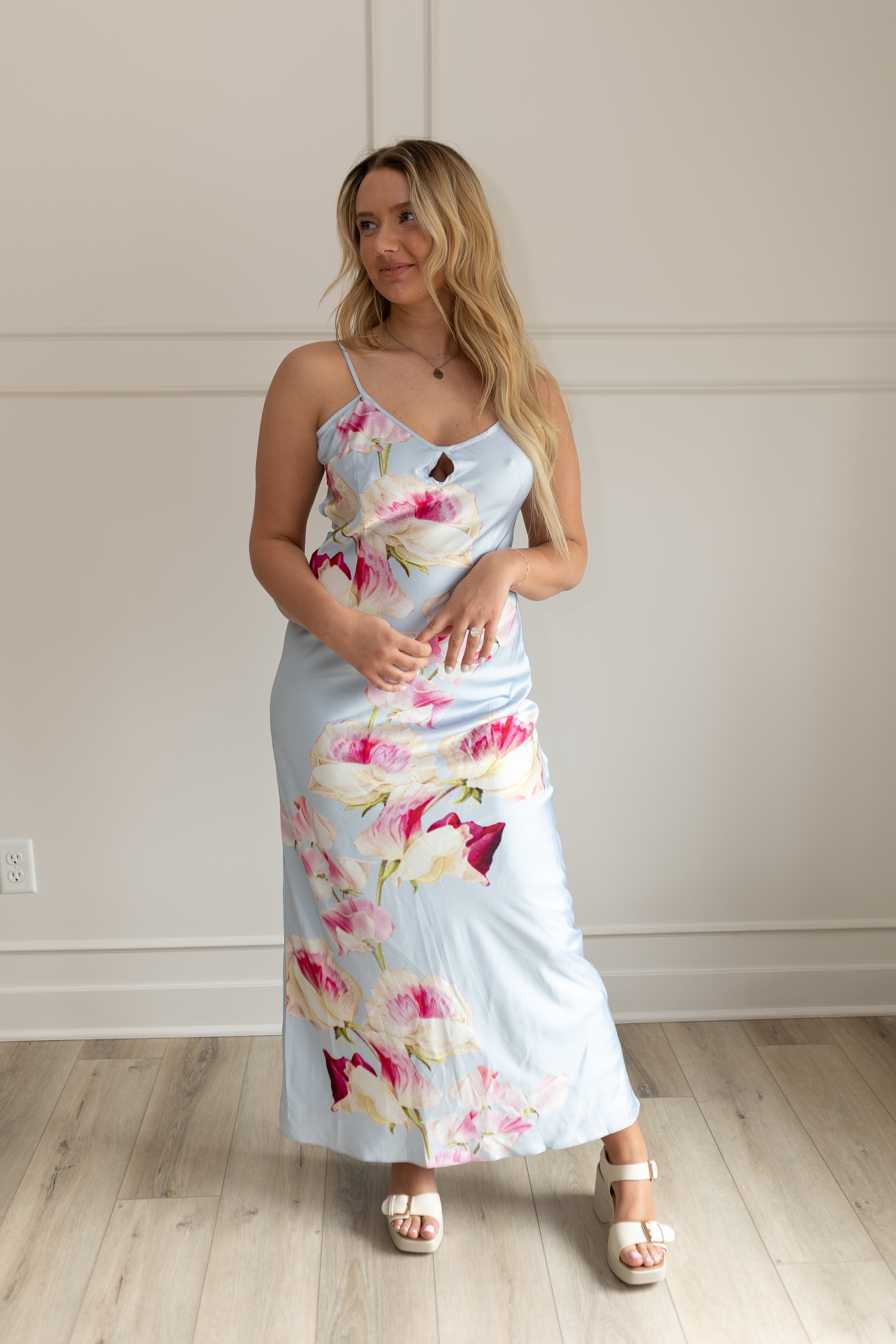 Blue satin maxi dress with pink floral pattern. Adjustable spaghetti straps and keyhole cutout. 