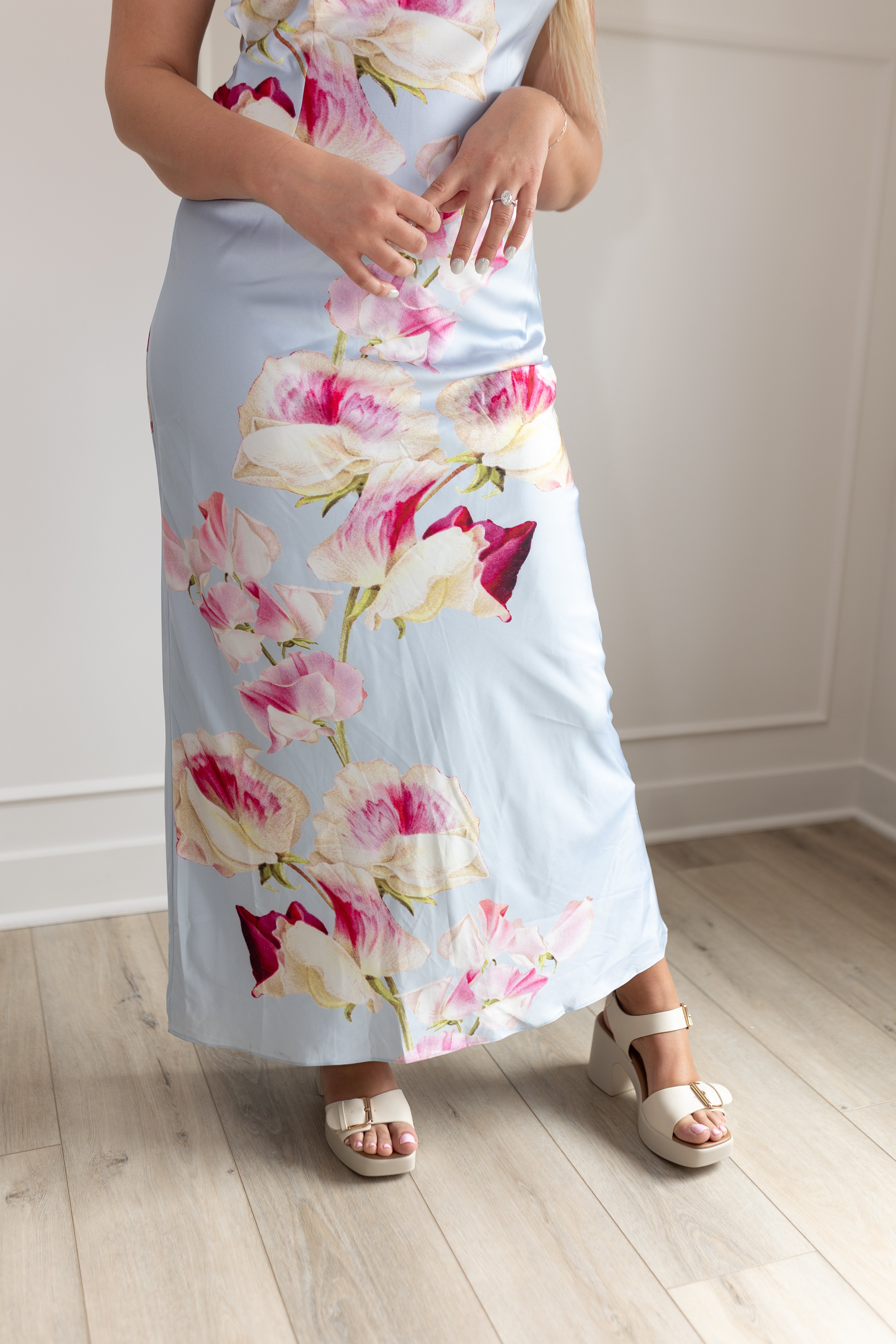 Blue satin maxi dress with pink floral pattern. Adjustable spaghetti straps and keyhole cutout. 