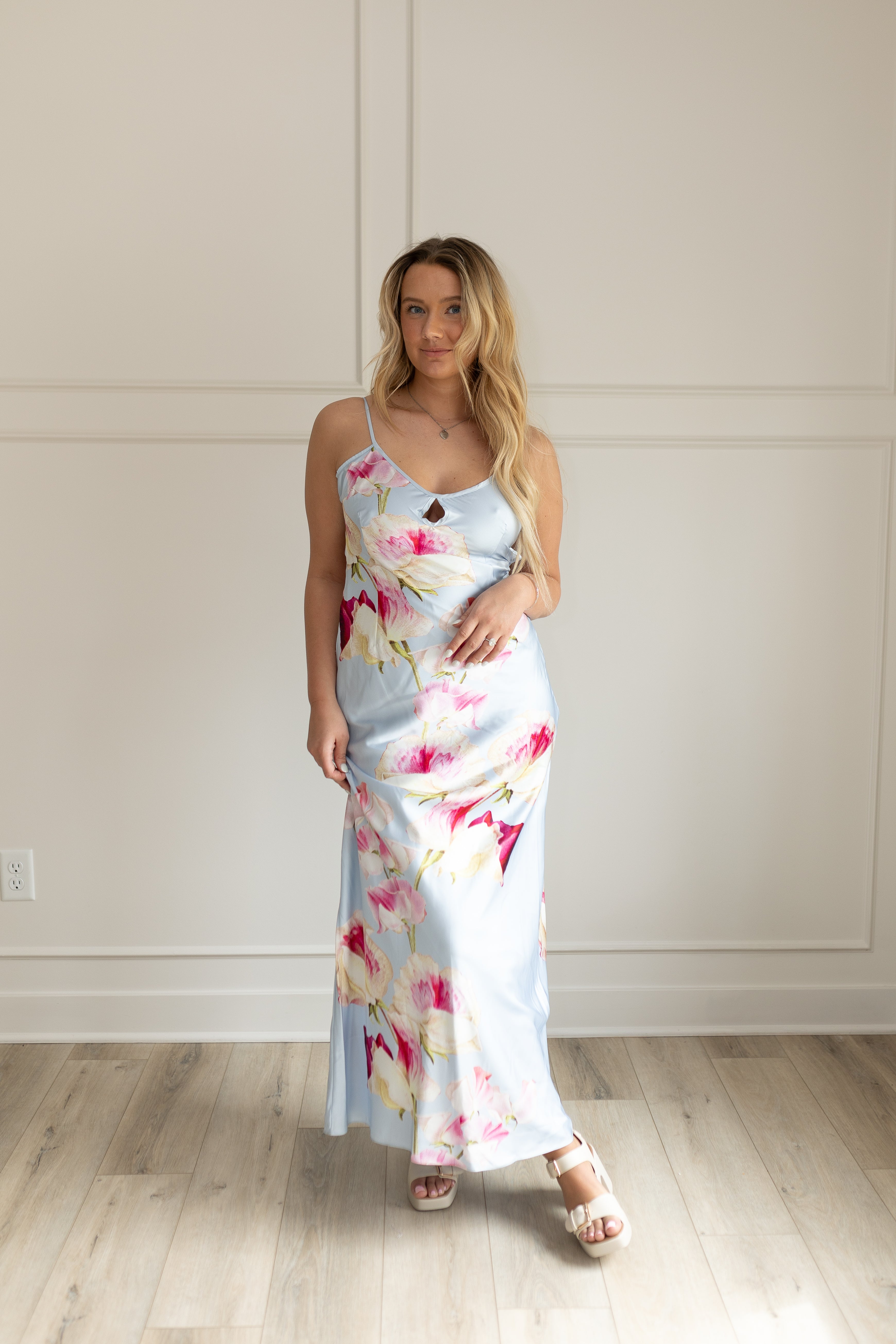 Blue satin maxi dress with pink floral pattern. Adjustable spaghetti straps and keyhole cutout. 