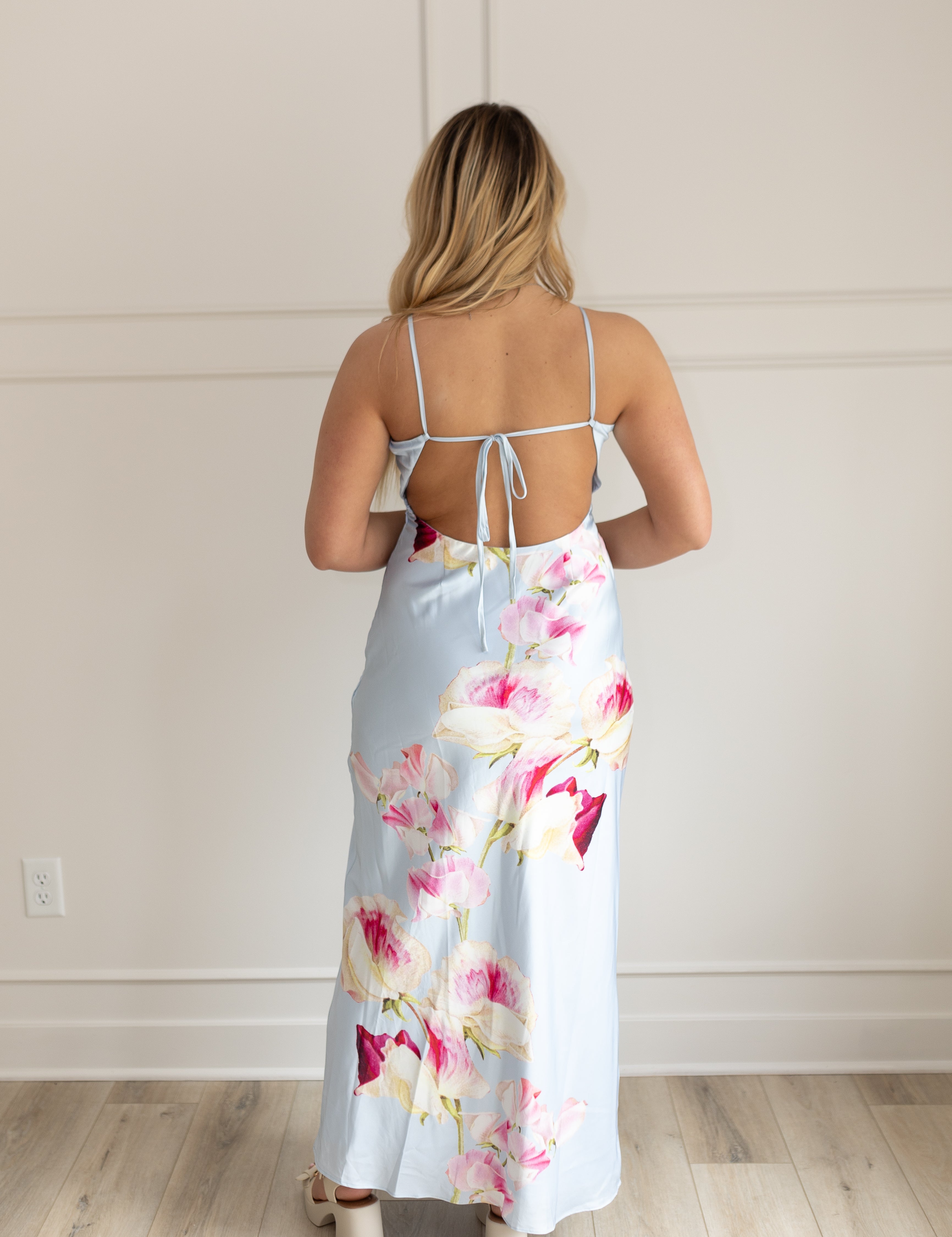 Blue satin maxi dress with pink floral pattern. Adjustable spaghetti straps and keyhole cutout. 