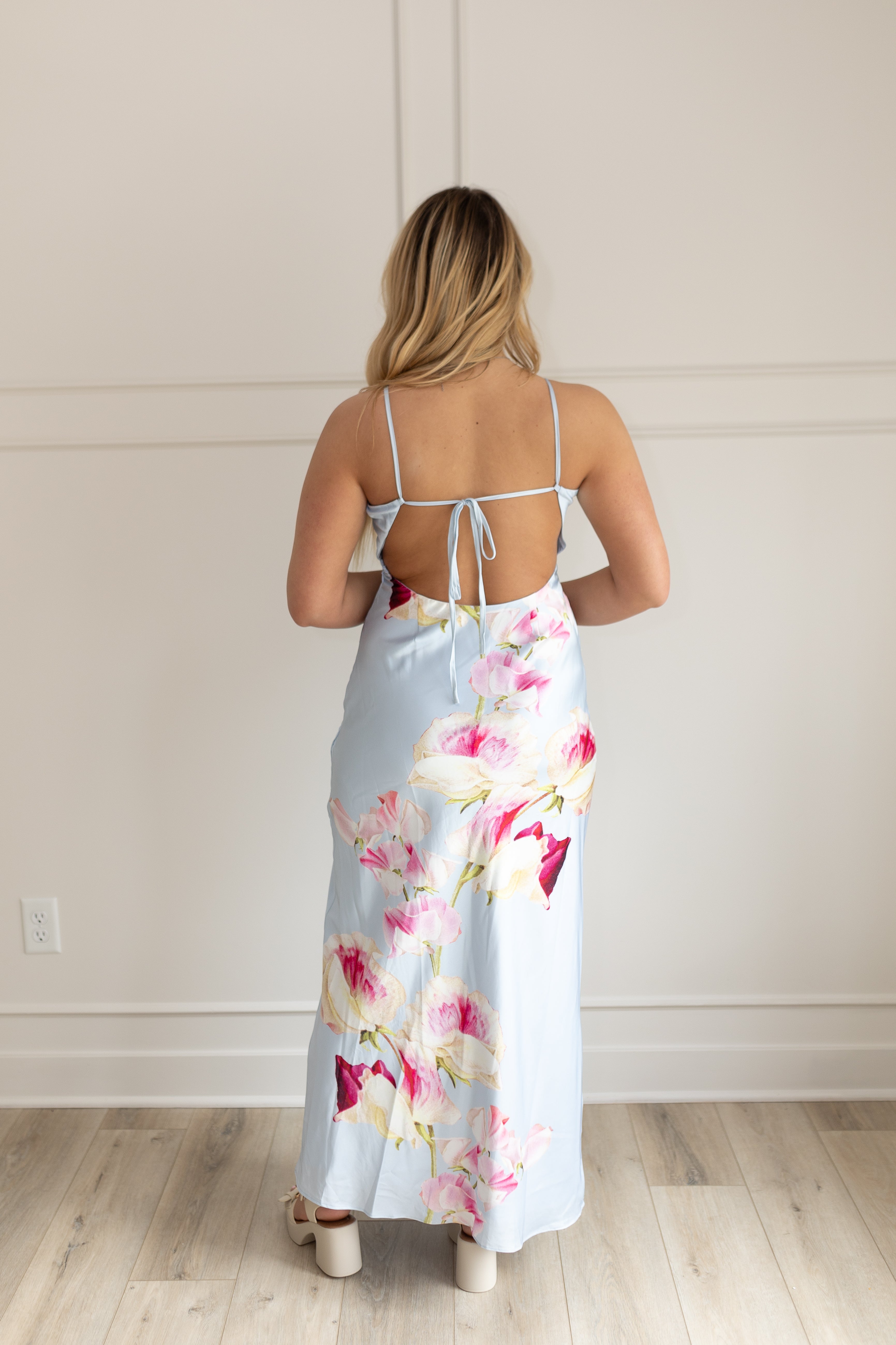 Blue satin maxi dress with pink floral pattern. Adjustable spaghetti straps and keyhole cutout. 