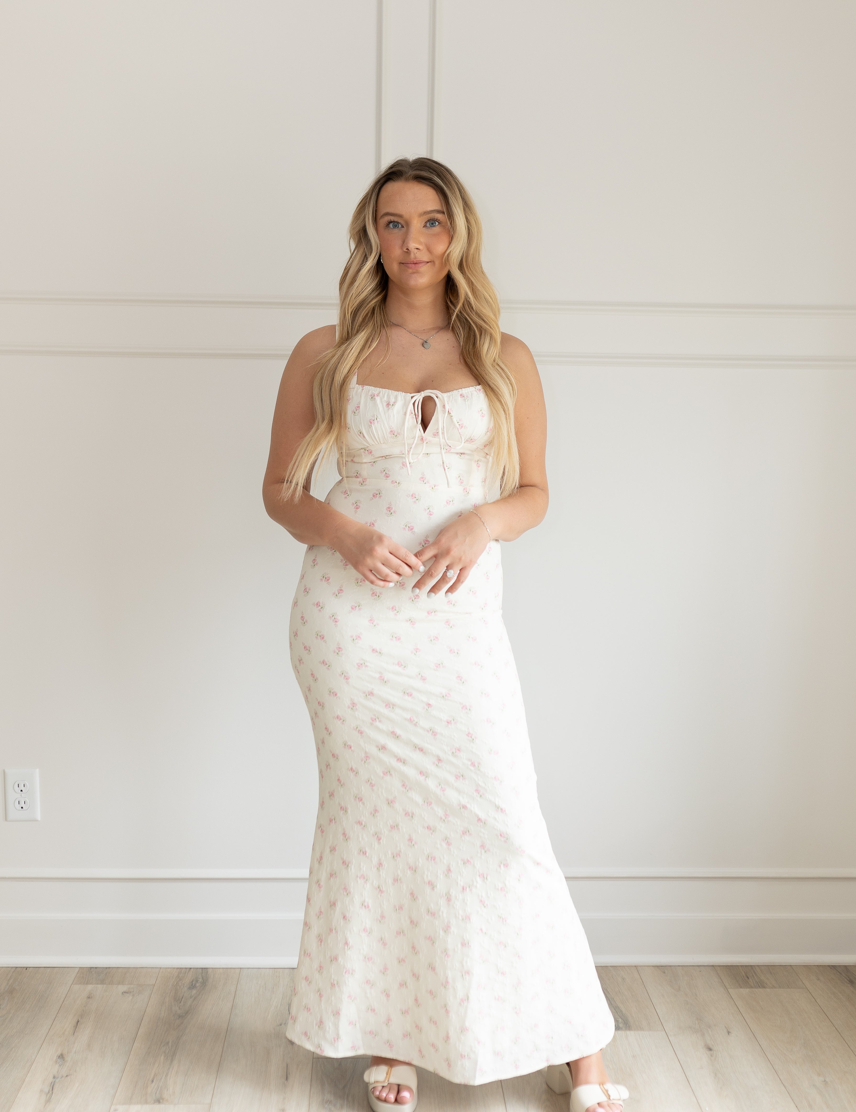 Cream colored maxi dress with pink floral pattern and lace up back. 