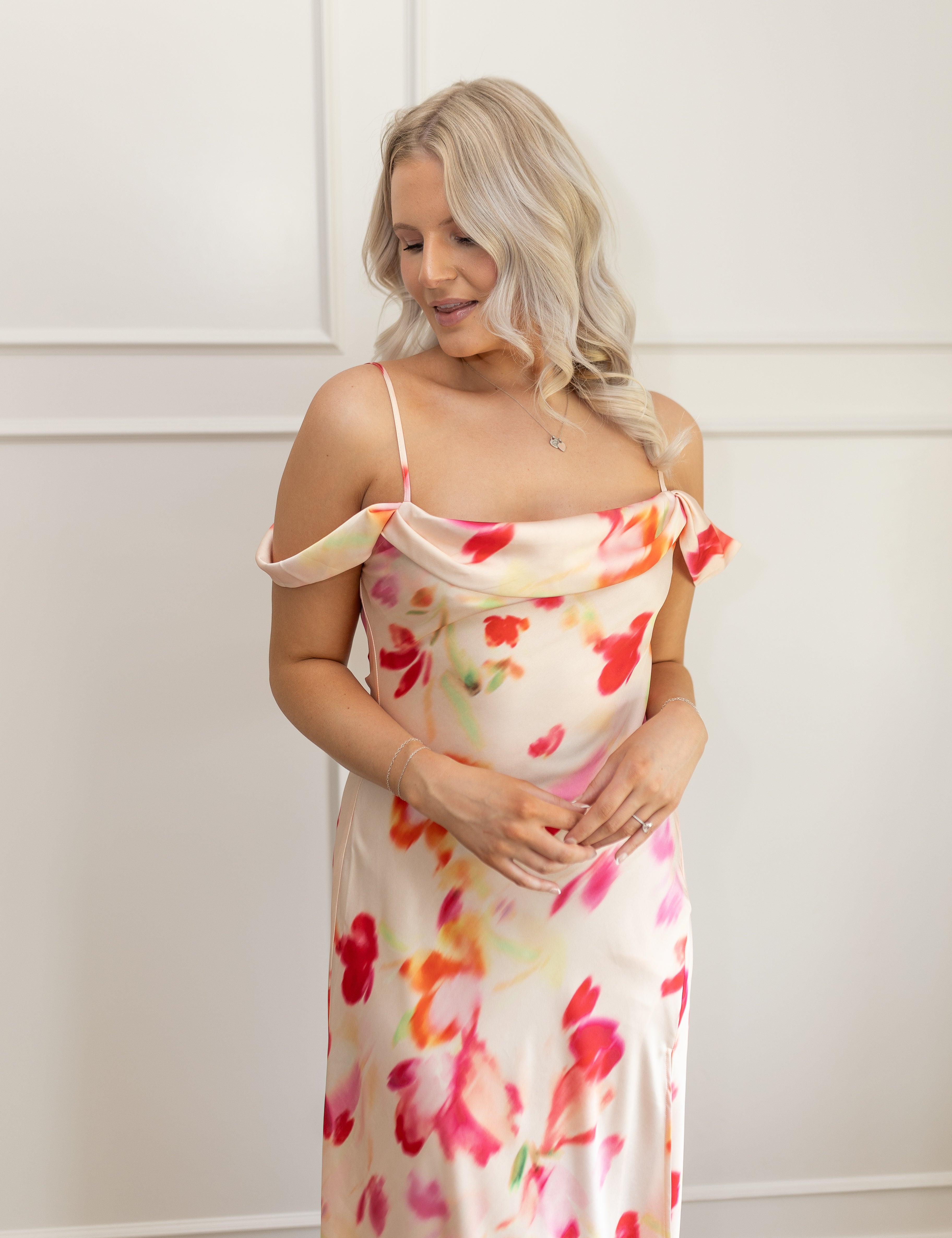 Model wearing off-the-shoulder floral midi dress with pink and red watercolor print