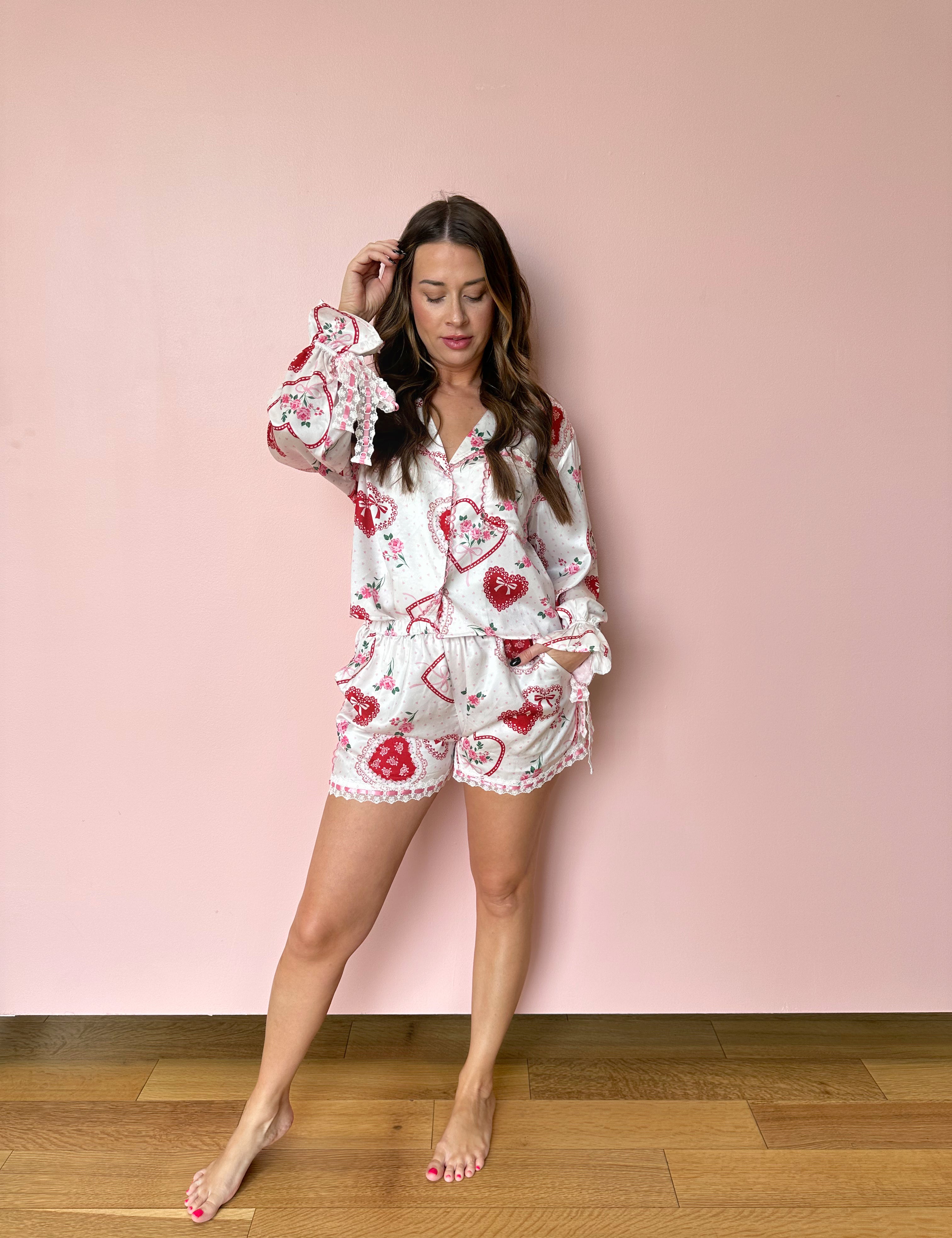 White satin pajama set with lace and heart detailing. 