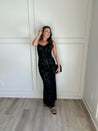 Black floral velvet maxi dress with spaghetti straps, cowl neckline, and sheer detailing for elegance.