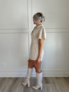 Beige eyelet romper with puff sleeves, zip-front closure, and functional pockets for stylish convenience.