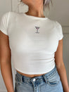 White cropped tee with martini glass embroidery and casual fitted design.