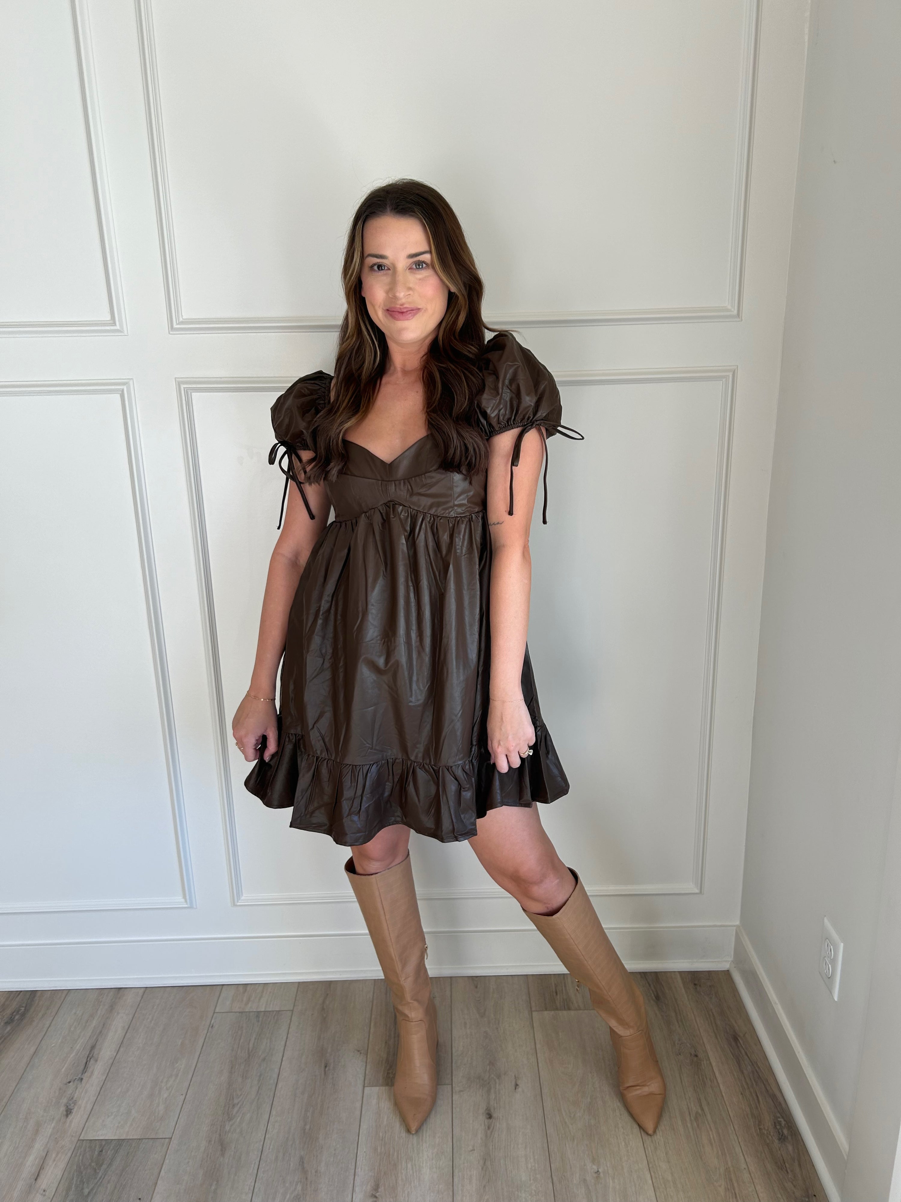 Brown faux leather babydoll dress with puff sleeves and ruffle hemline.