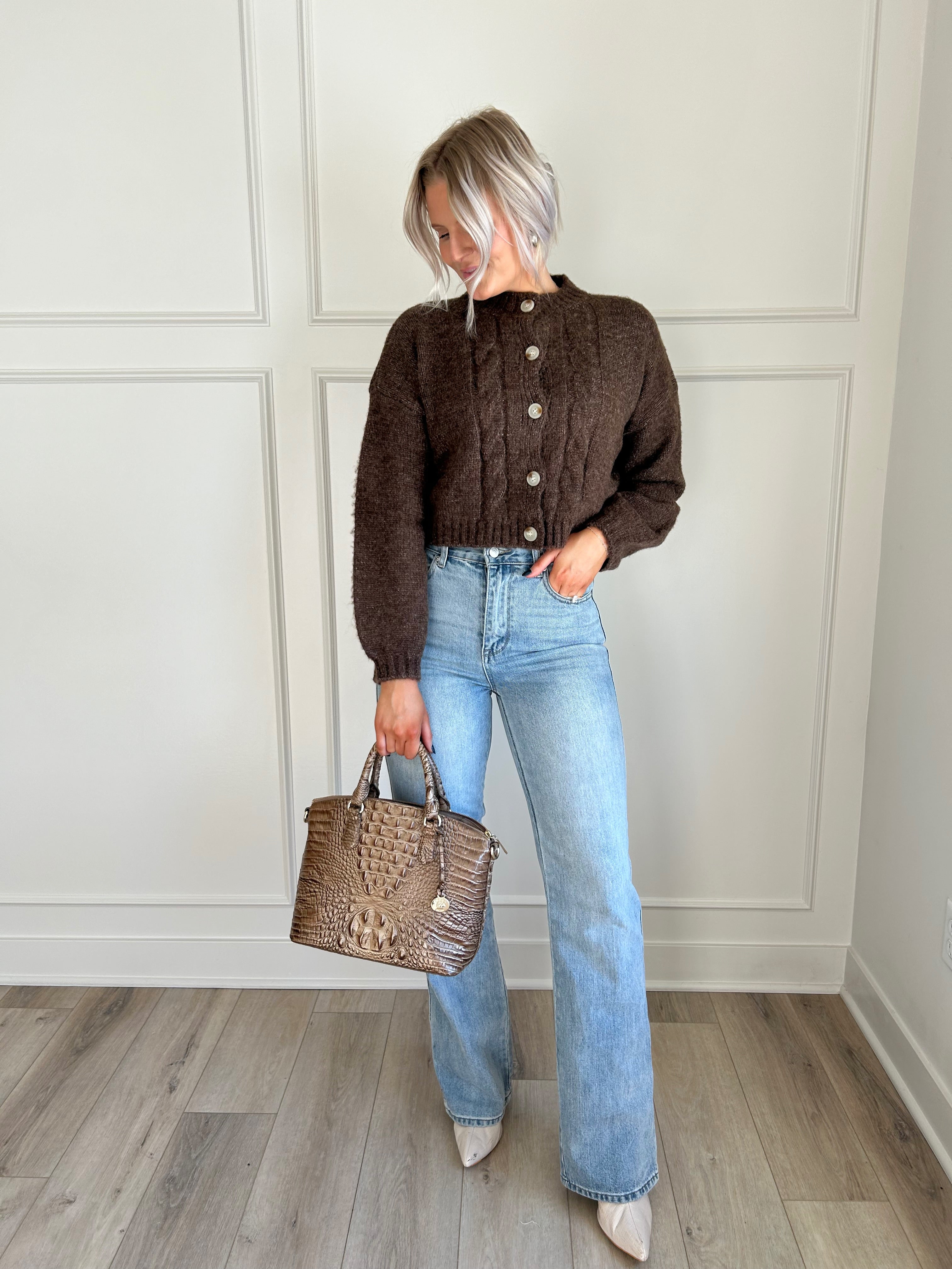 Brown cropped cable knit sweater with button-up front and cozy fit.