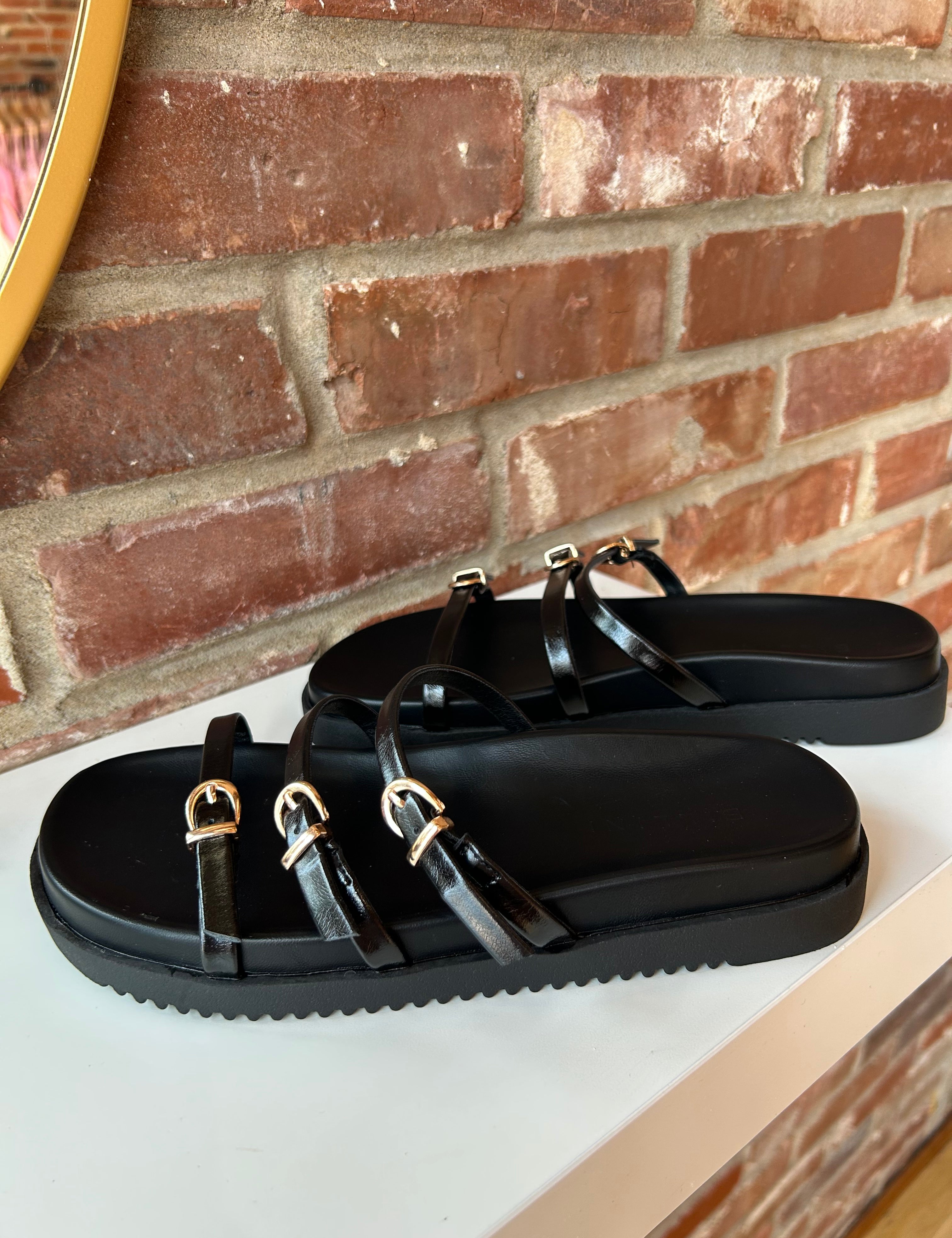 Billini Lacy Black Sandal with slim straps, gold buckles, and a cushioned sole for a modern, stylish, and comfortable fit