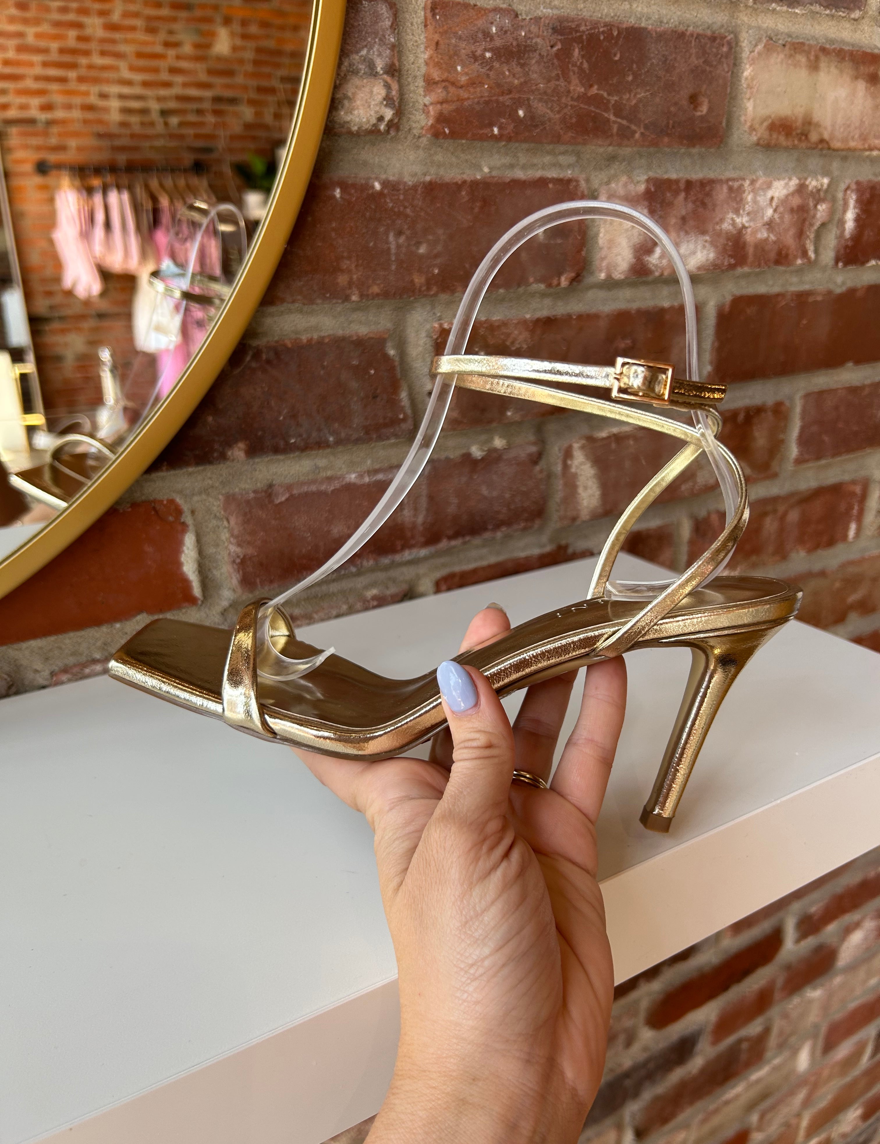Alani Gold Strappy Heel with a metallic finish, slim straps, and a stiletto heel for an elegant and modern style.
