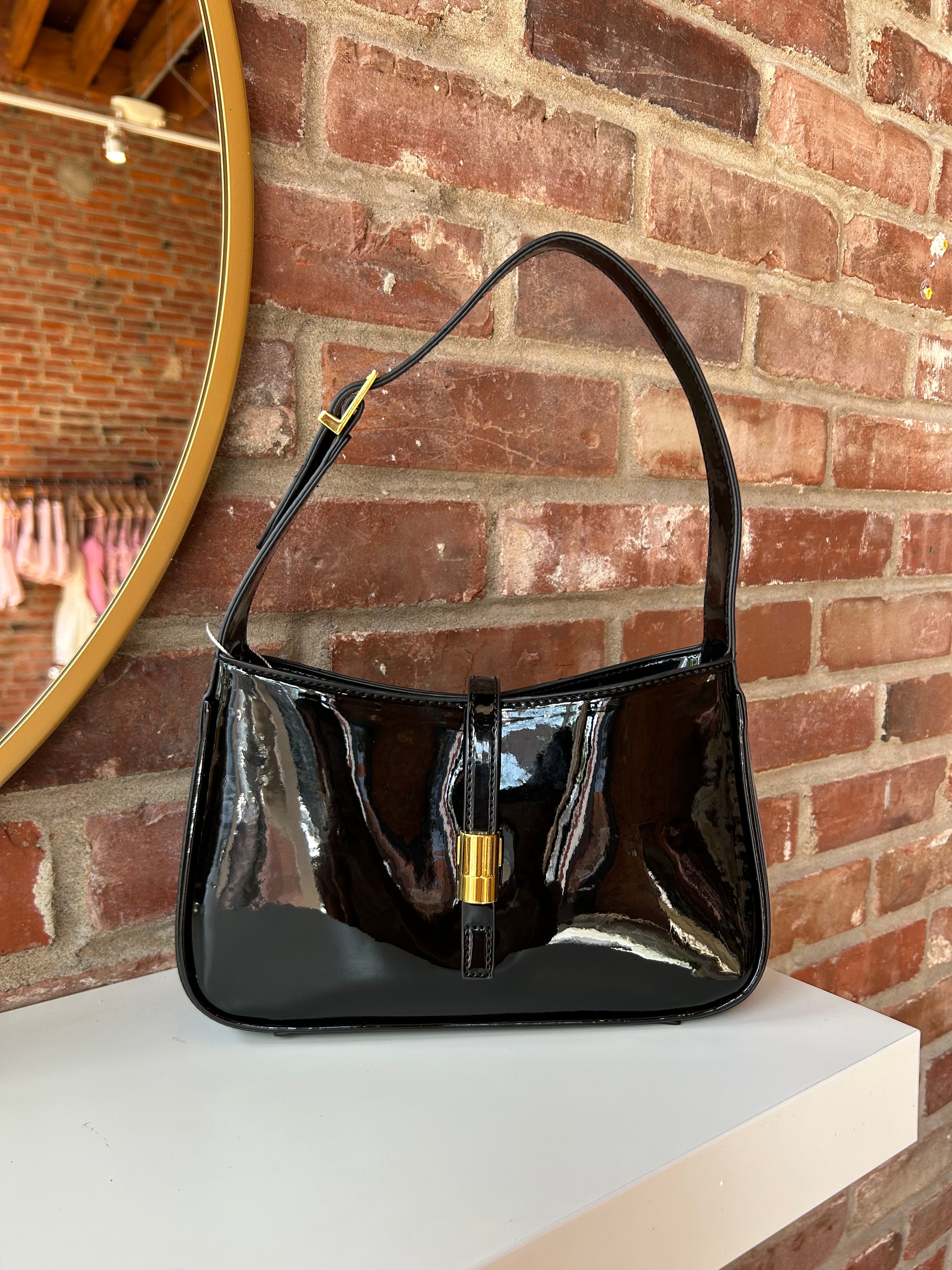 Black patent leather shoulder bag with gold hardware. Perfect for everyday use