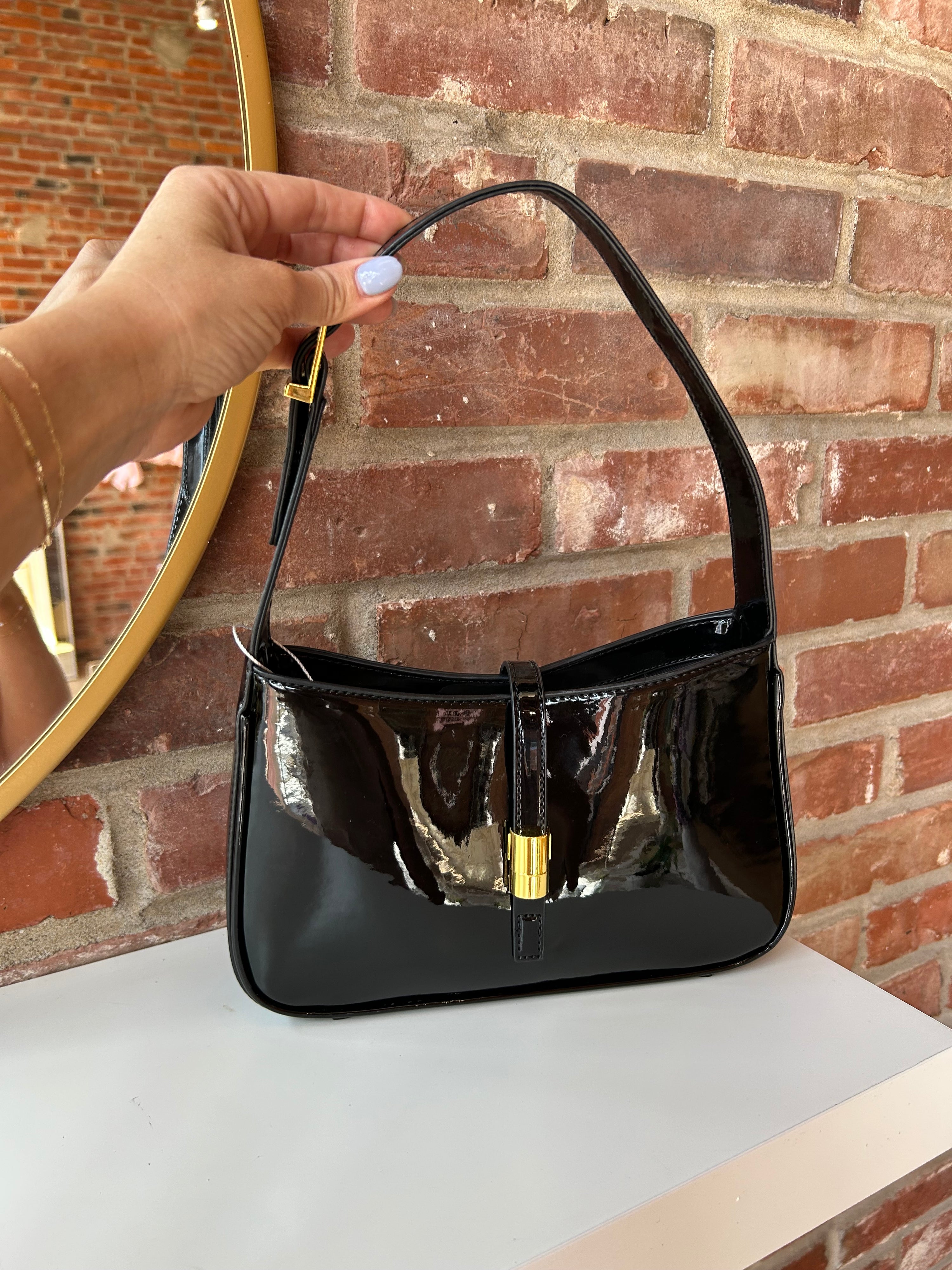 Black patent leather shoulder bag with gold hardware. Perfect for everyday use