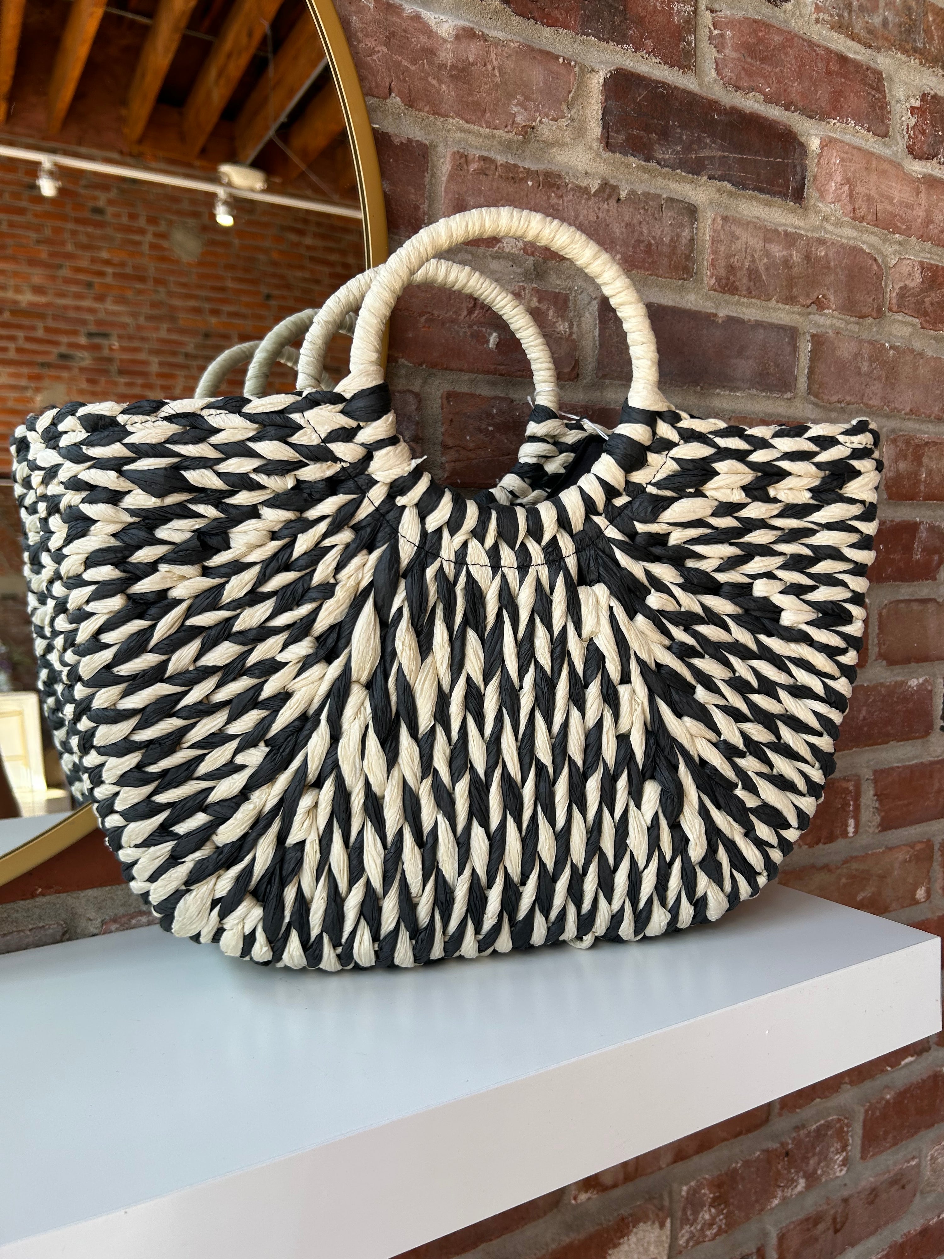 Black and tan straw woven tote bag. Perfect for vacation or carrying all summer. 