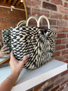 Black and tan straw woven tote bag. Perfect for vacation or carrying all summer. 