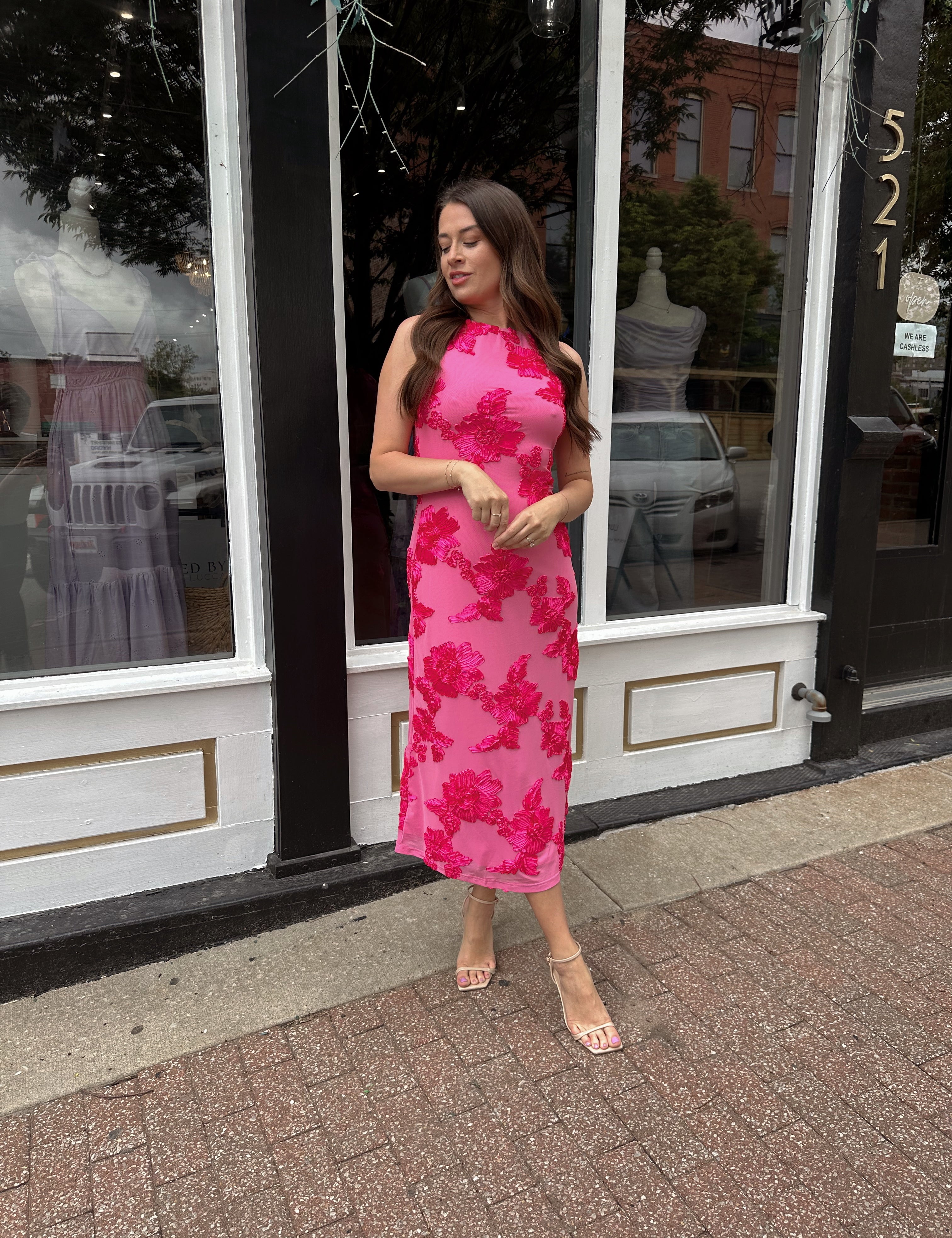 Woman wearing fuchsia floral halter midi dress with pink base and bold floral print