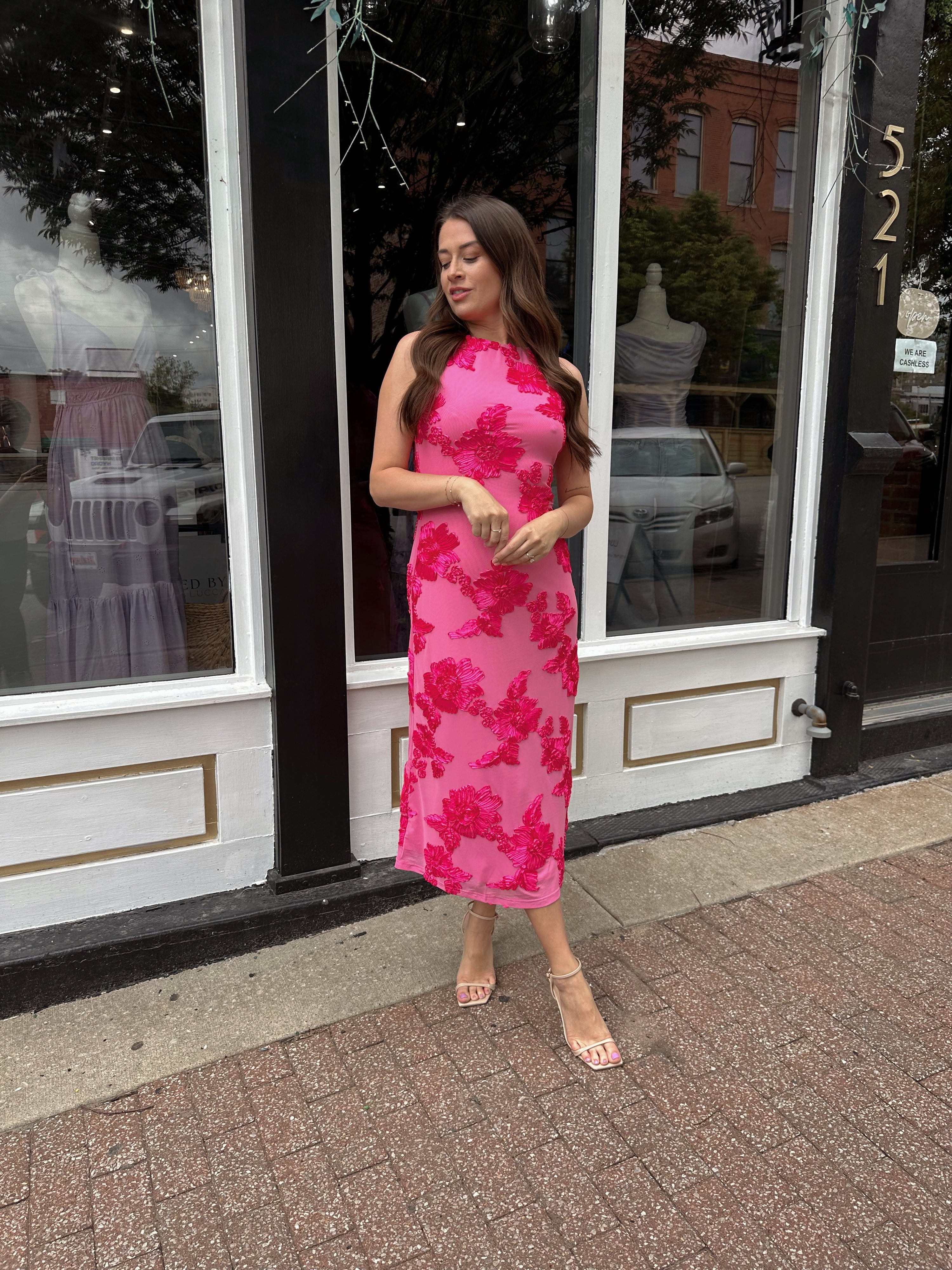 Woman wearing fuchsia floral halter midi dress with pink base and bold floral print