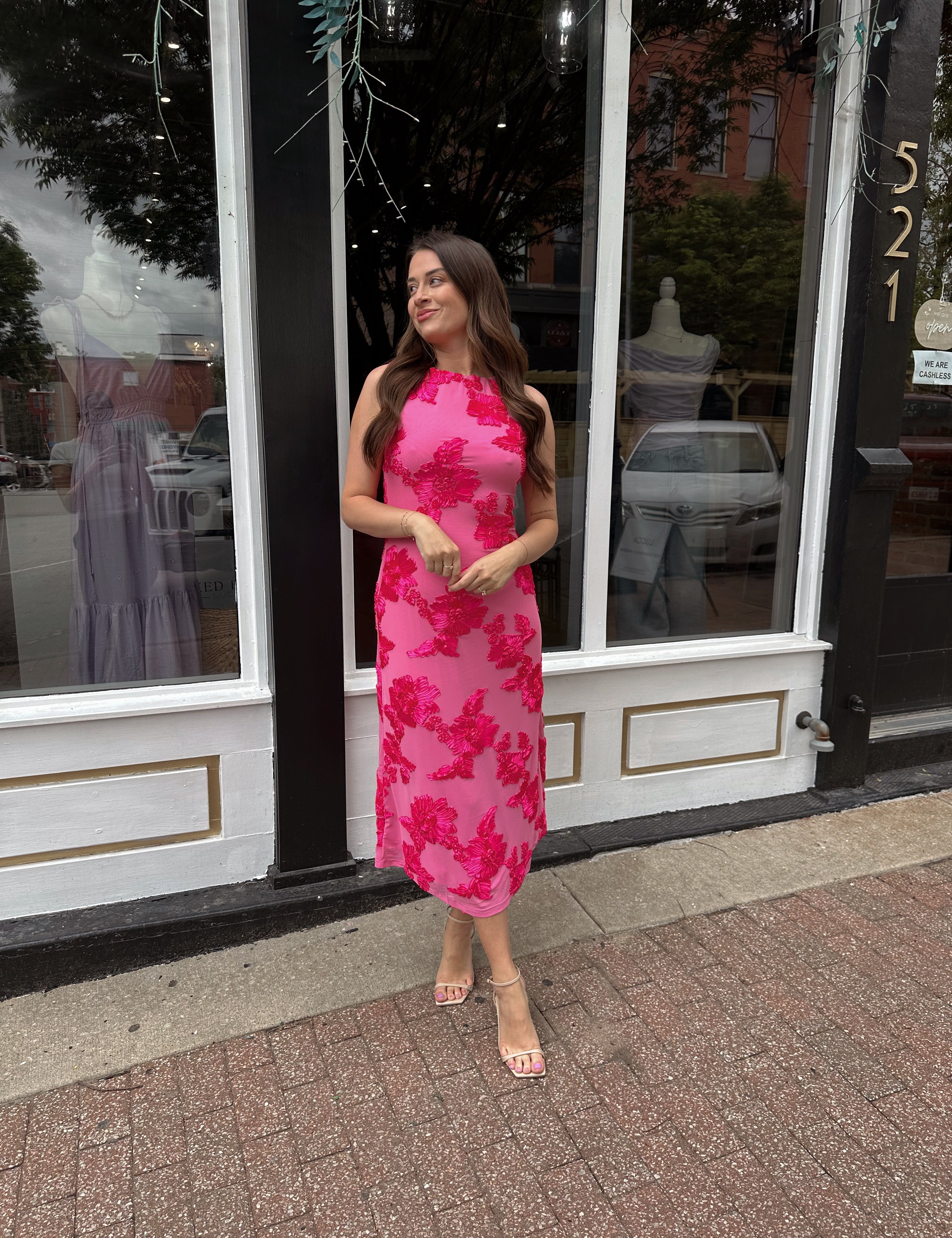 Woman wearing fuchsia floral halter midi dress with pink base and bold floral print