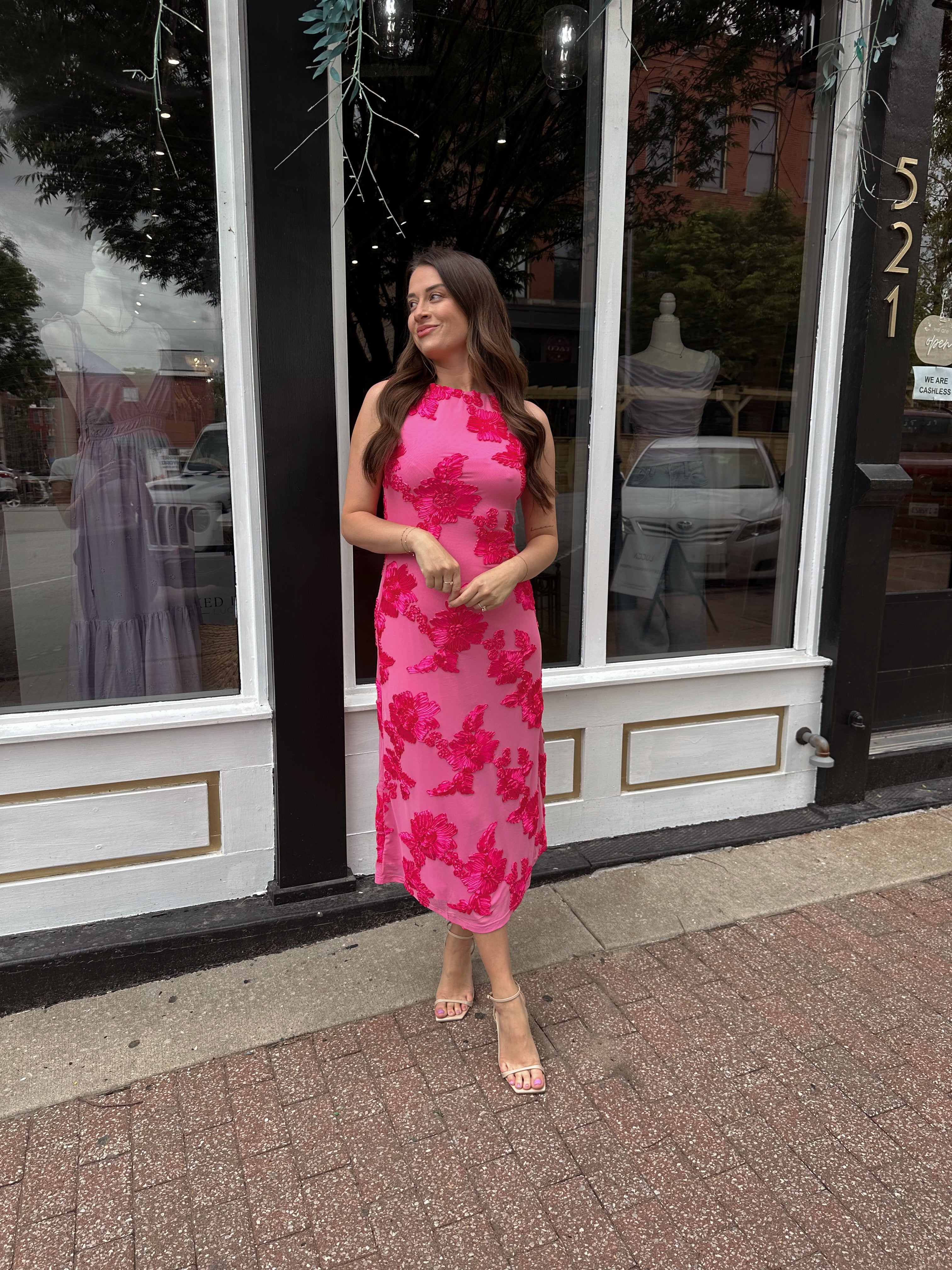 Woman wearing fuchsia floral halter midi dress with pink base and bold floral print