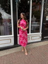 Woman wearing fuchsia floral halter midi dress with pink base and bold floral print