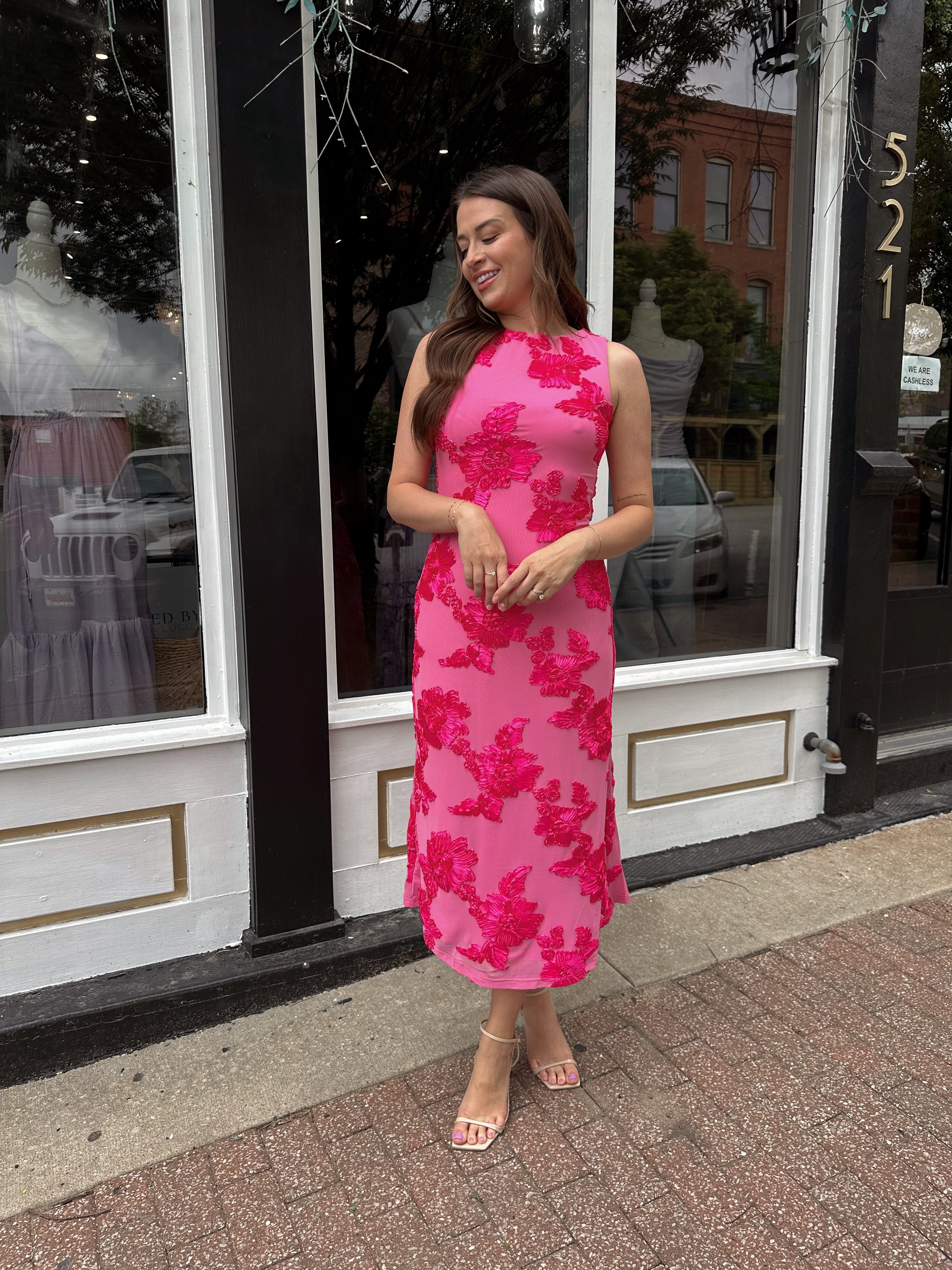 Woman wearing fuchsia floral halter midi dress with pink base and bold floral print