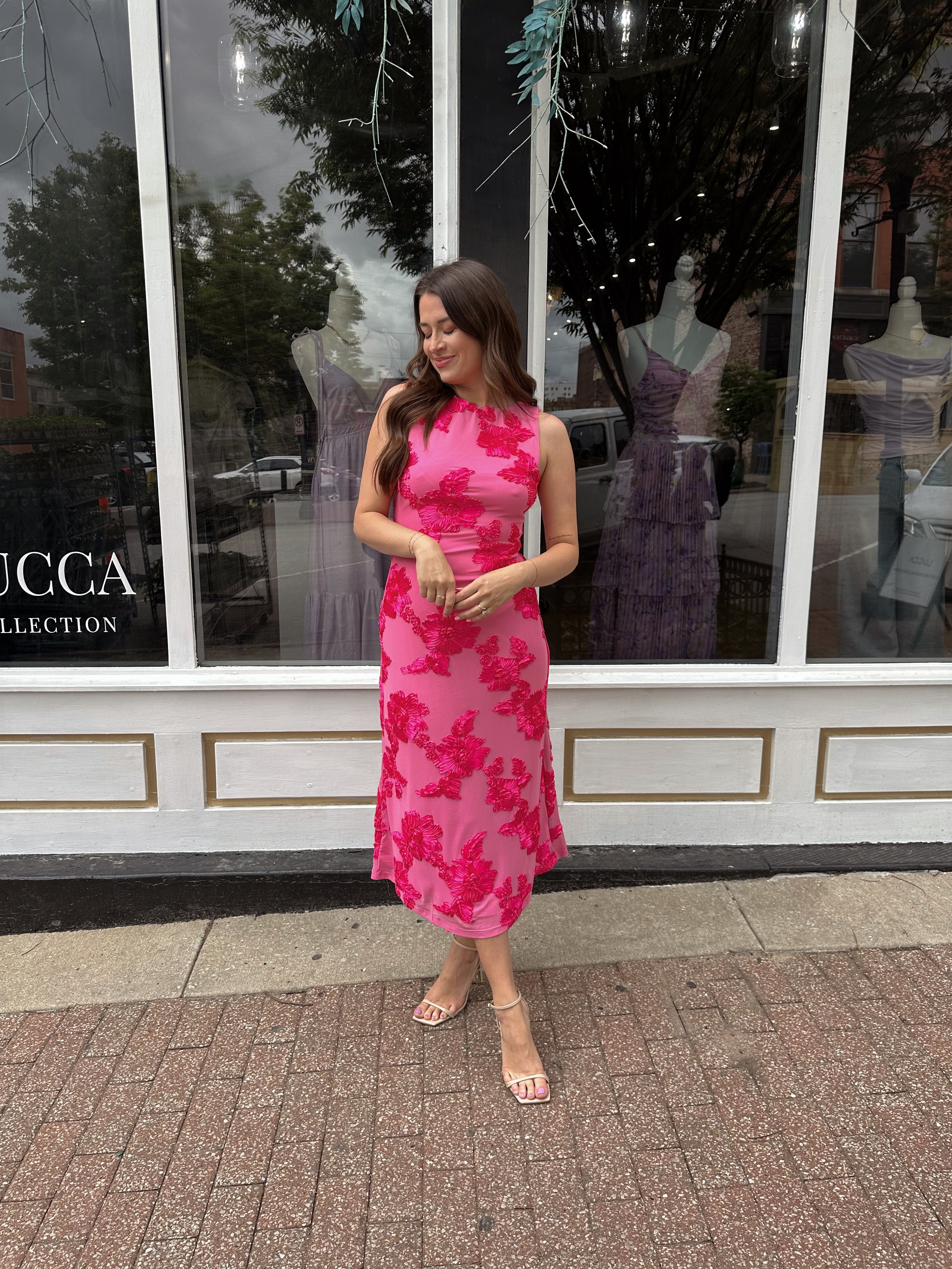 Woman wearing fuchsia floral halter midi dress with pink base and bold floral print