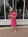 Woman wearing fuchsia floral halter midi dress with pink base and bold floral print