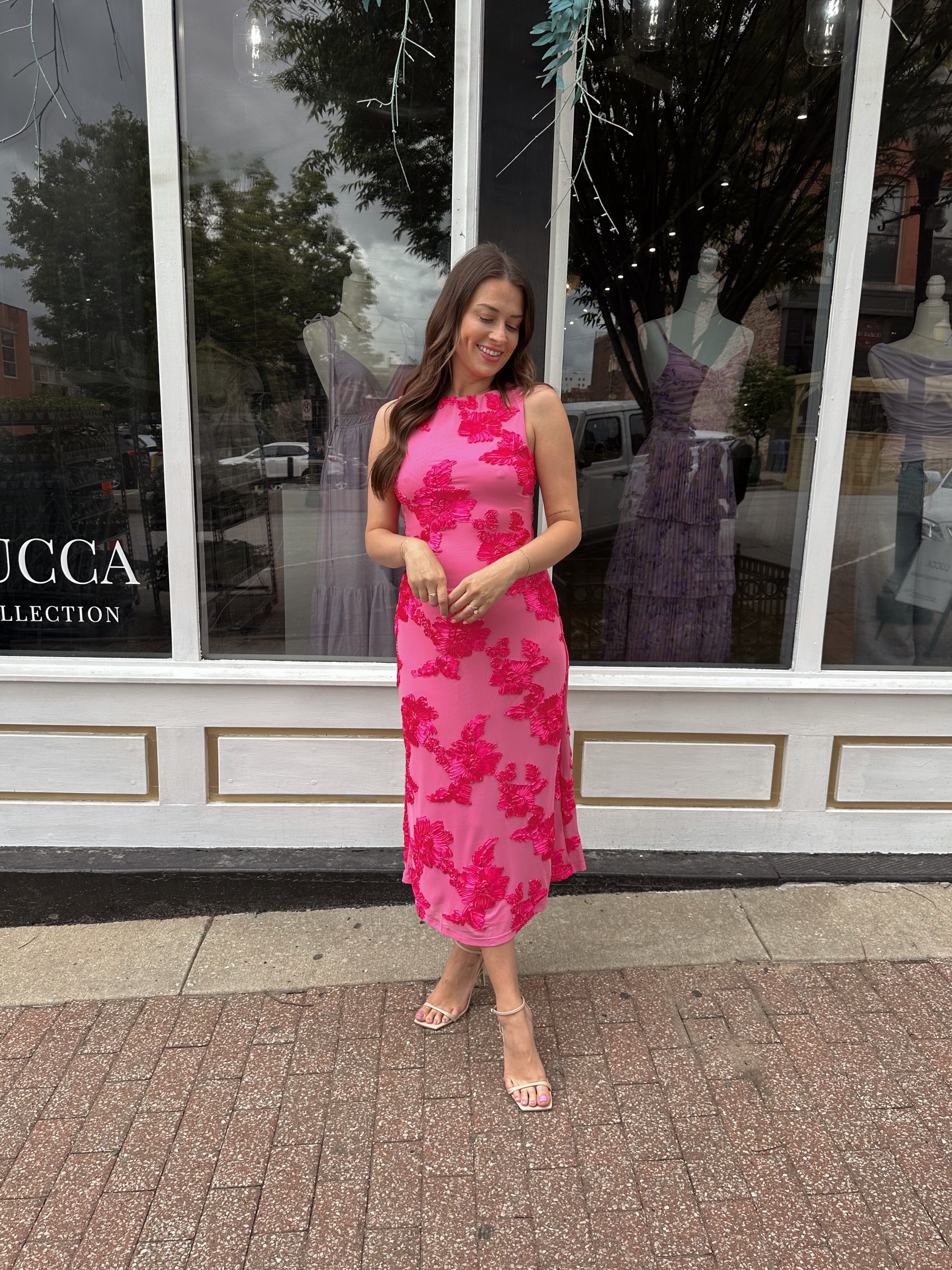 Woman wearing fuchsia floral halter midi dress with pink base and bold floral print