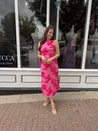 Woman wearing fuchsia floral halter midi dress with pink base and bold floral print