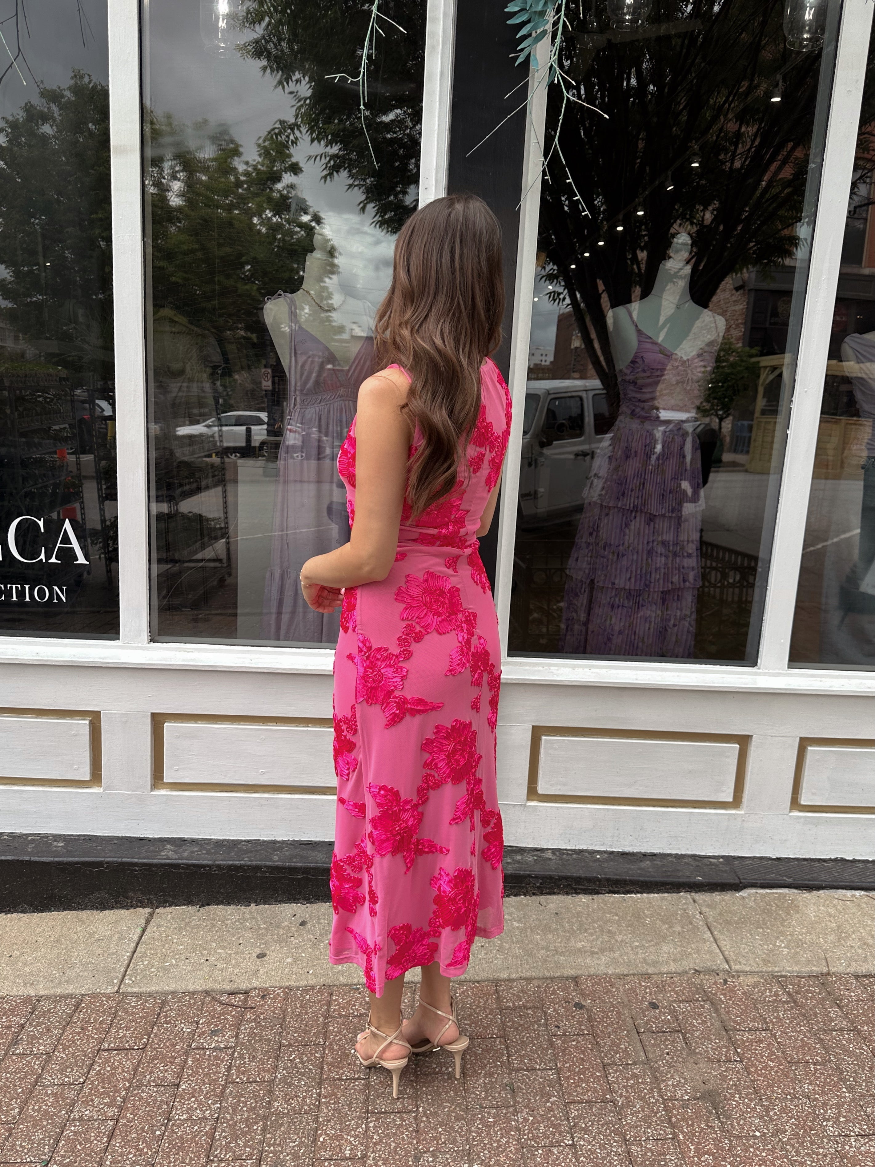 Woman wearing fuchsia floral halter midi dress with pink base and bold floral print