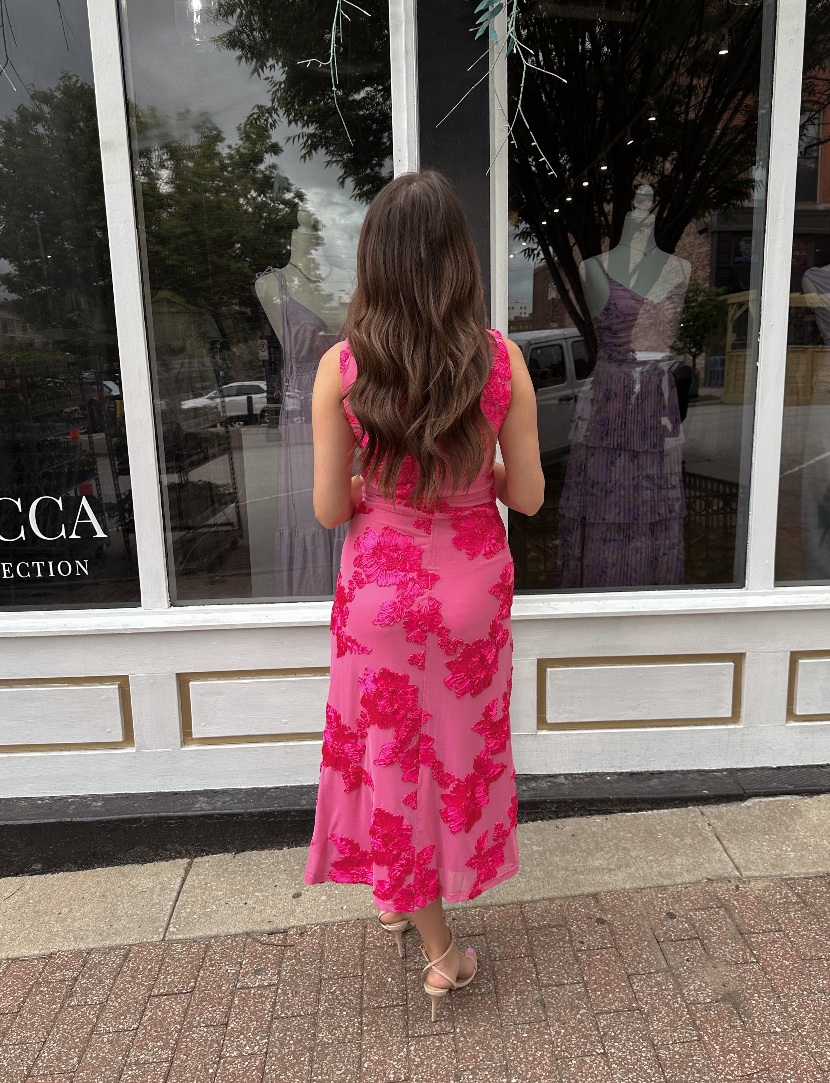 Woman wearing fuchsia floral halter midi dress with pink base and bold floral print