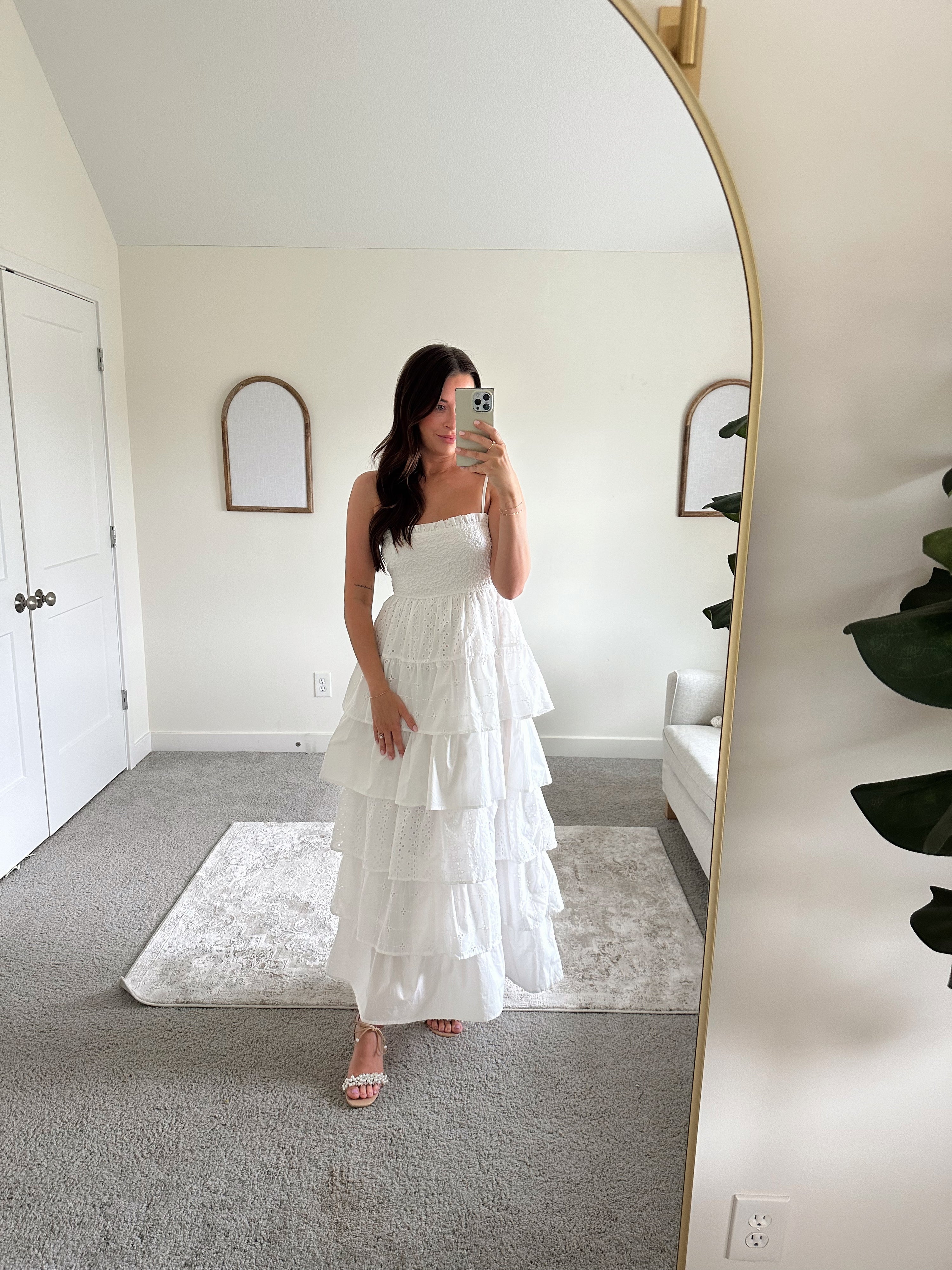 Woman in white smocked midi dress with tiered eyelet fabric and thin straps