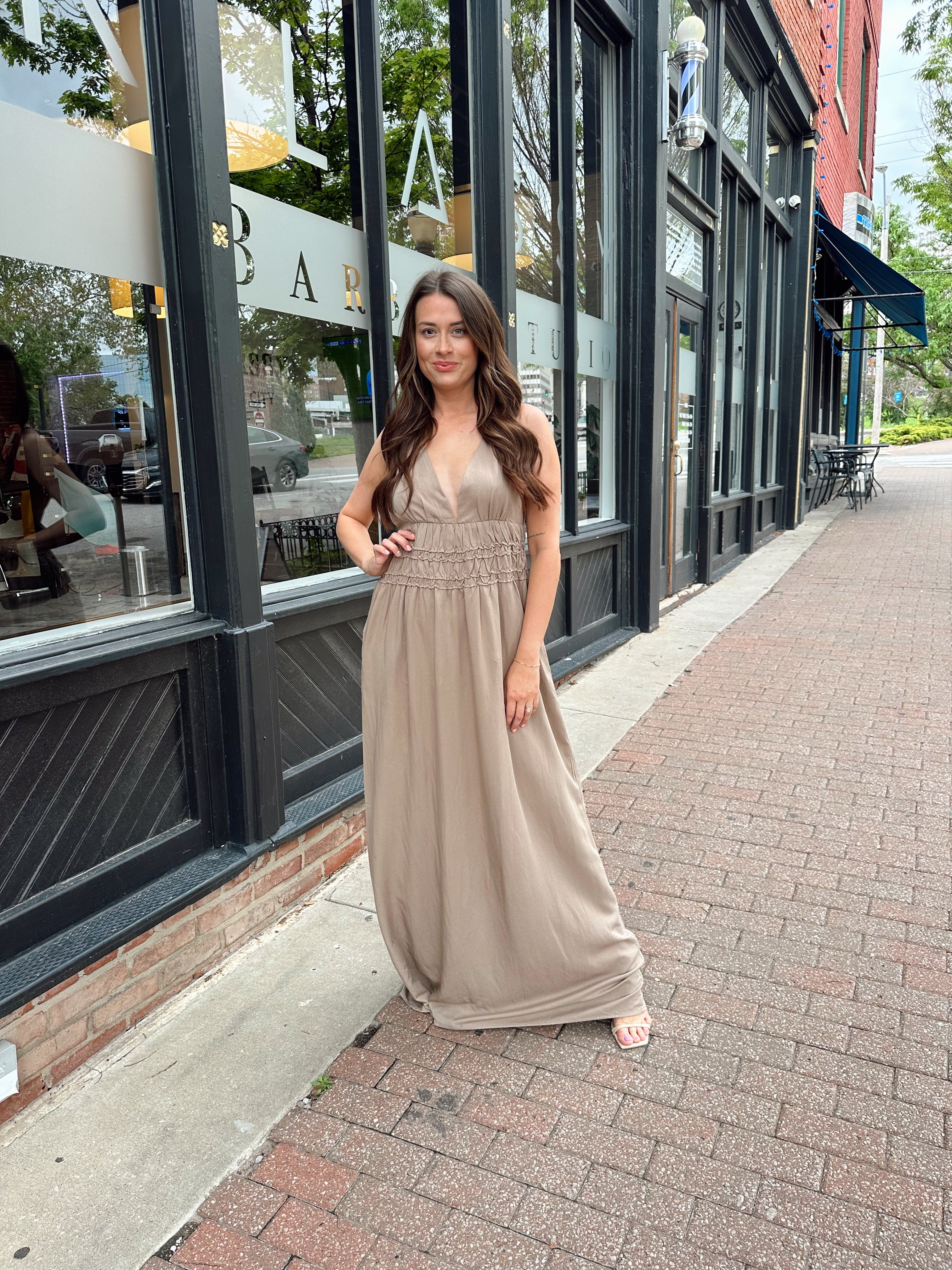 Beige ruched maxi dress with plunging neckline and open crisscross back detail