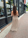 Beige ruched maxi dress with plunging neckline and open crisscross back detail