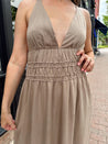 Beige ruched maxi dress with plunging neckline and open crisscross back detail