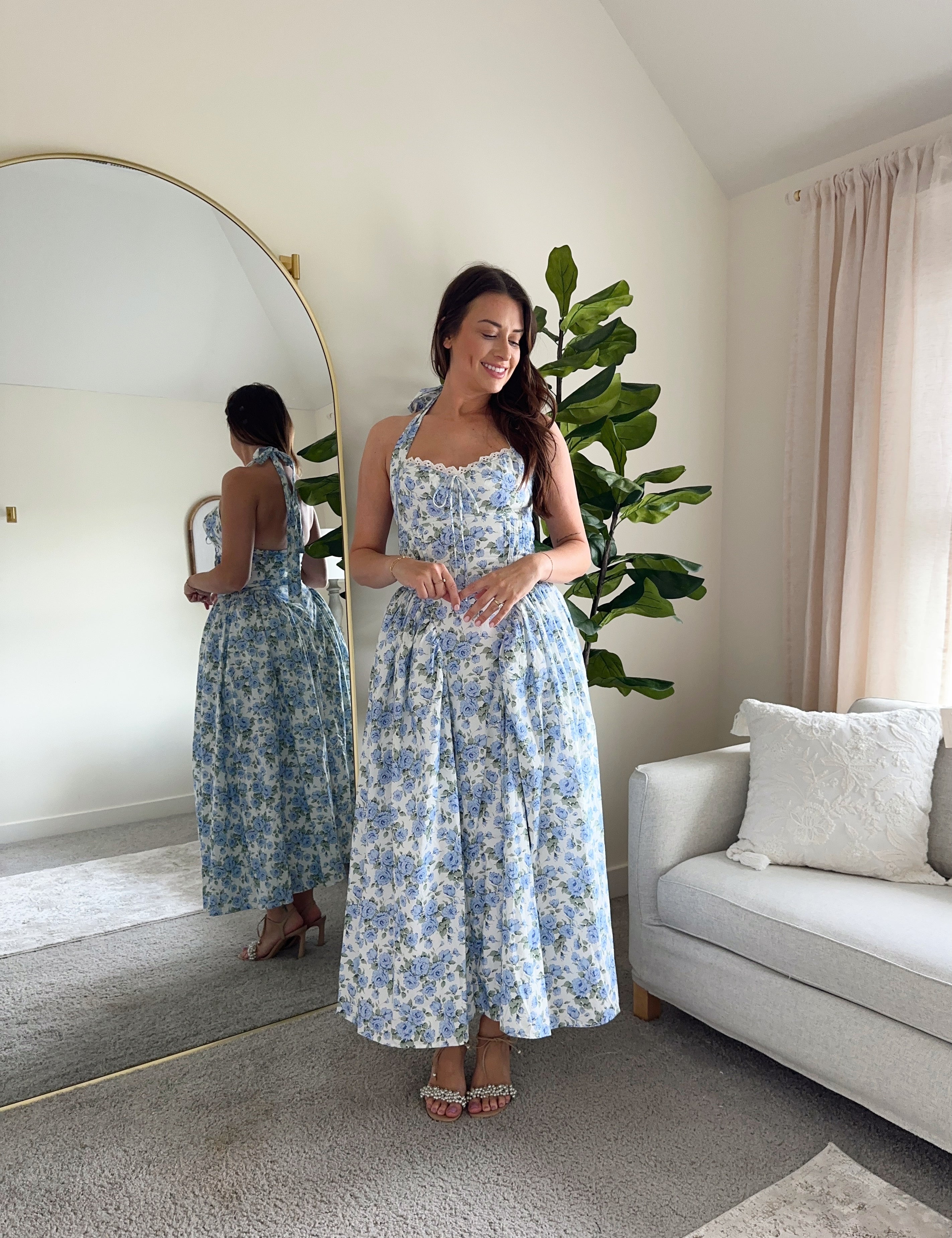 Woman in blue floral halter neck midi dress with lace trim and open back