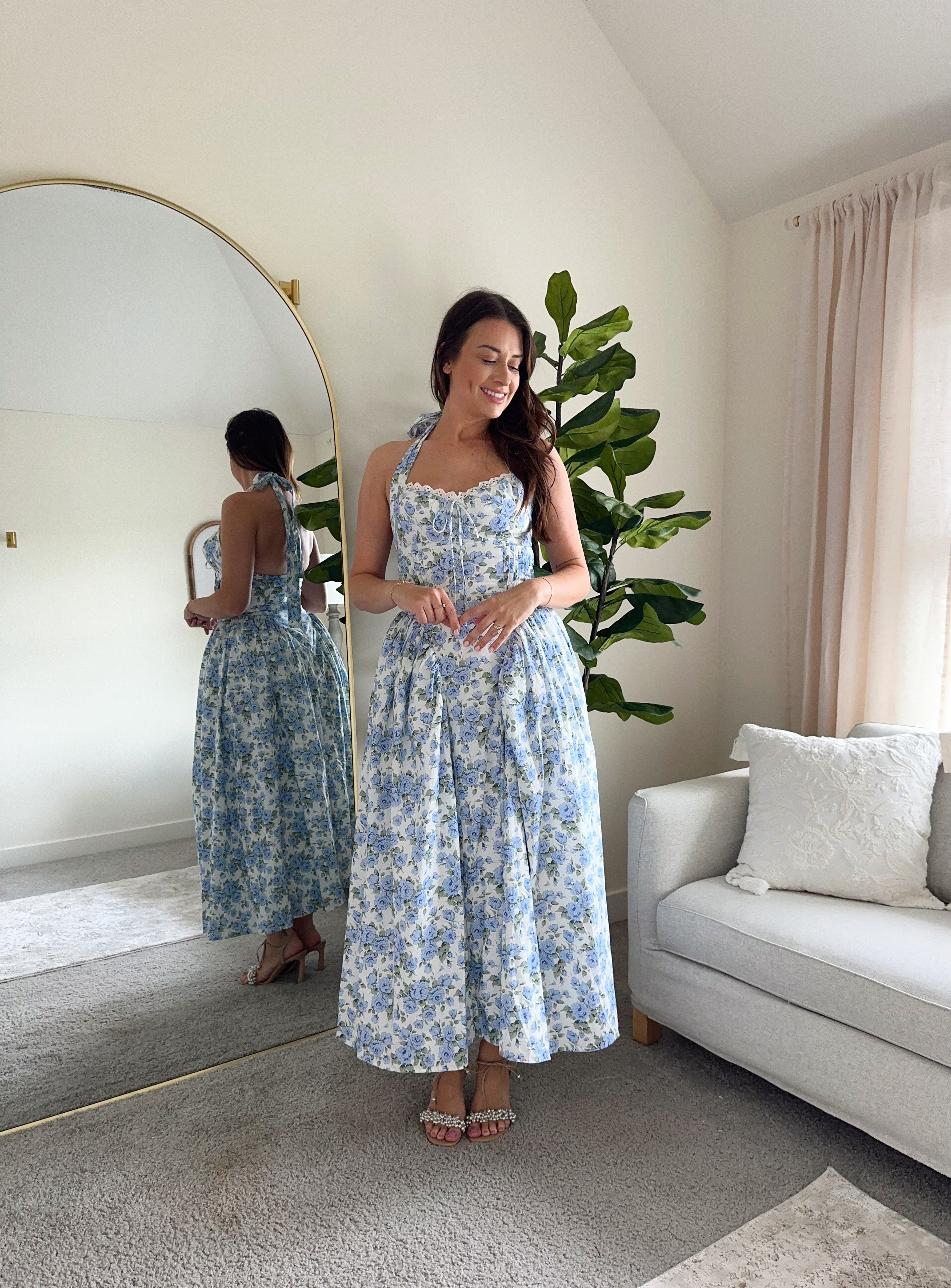 Woman in blue floral halter neck midi dress with lace trim and open back