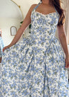 Woman in blue floral halter neck midi dress with lace trim and open back