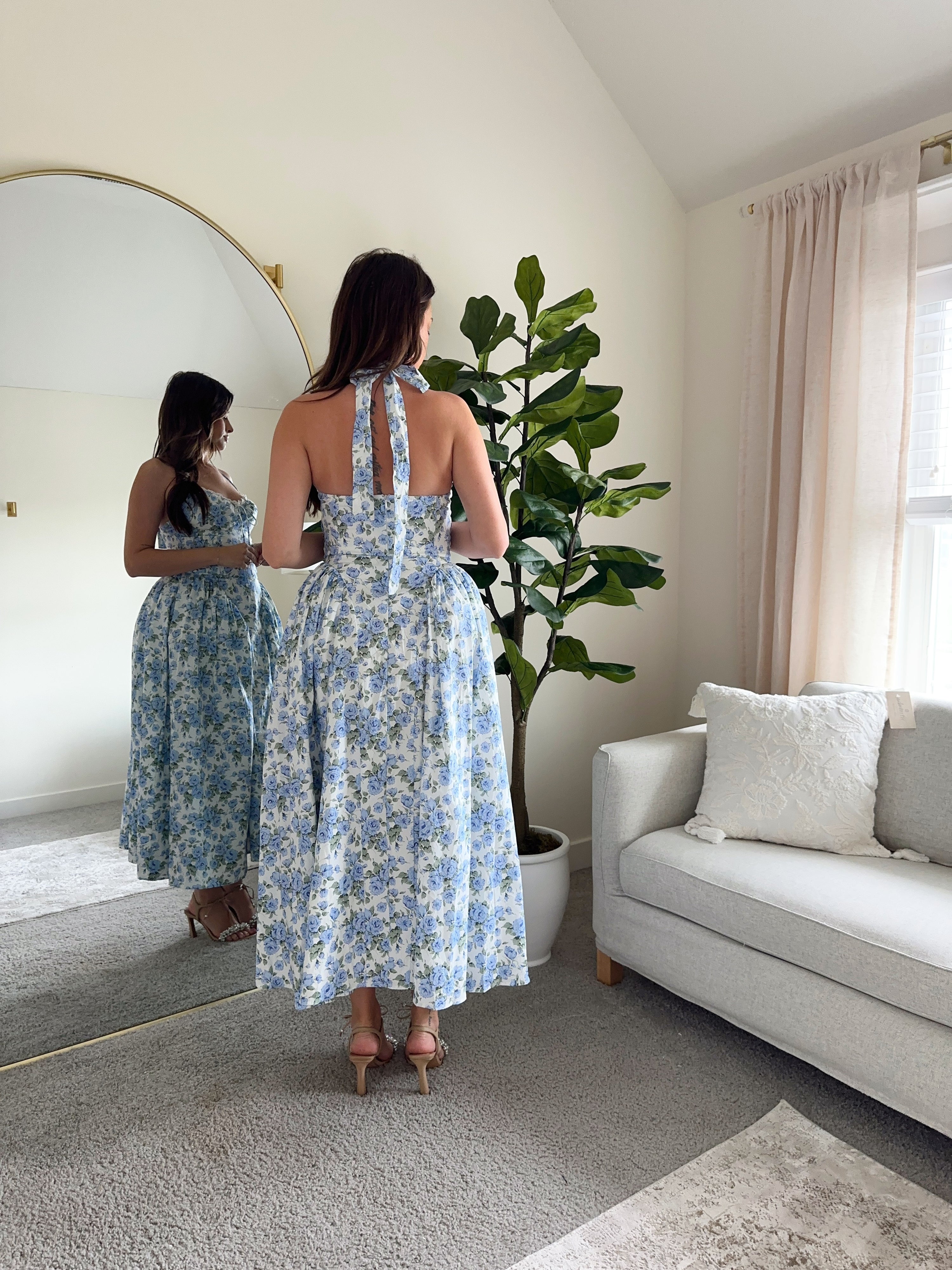 Woman in blue floral halter neck midi dress with lace trim and open back