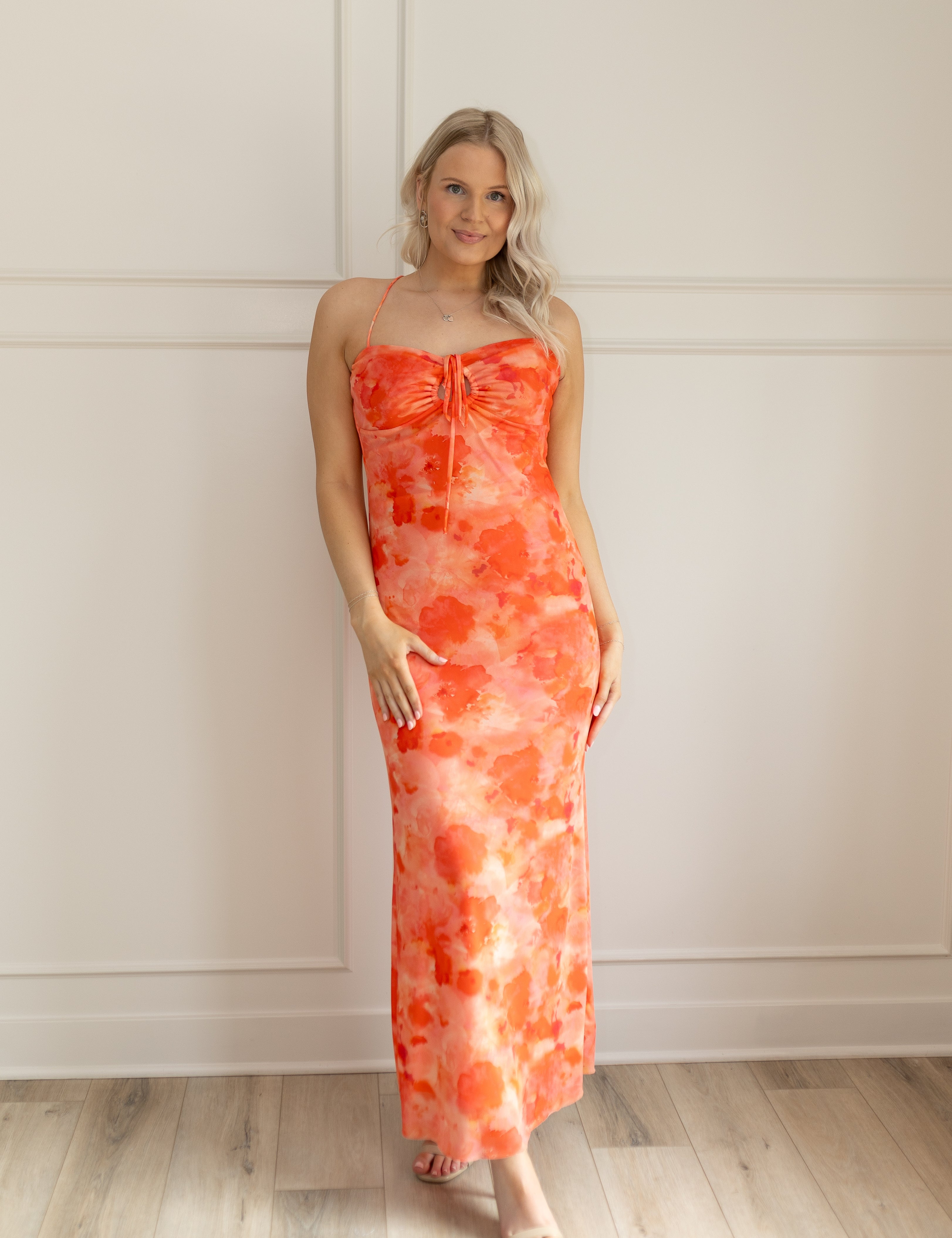Orange mesh floral mini dress with adjustable spaghetti straps and keyhole cutout. 