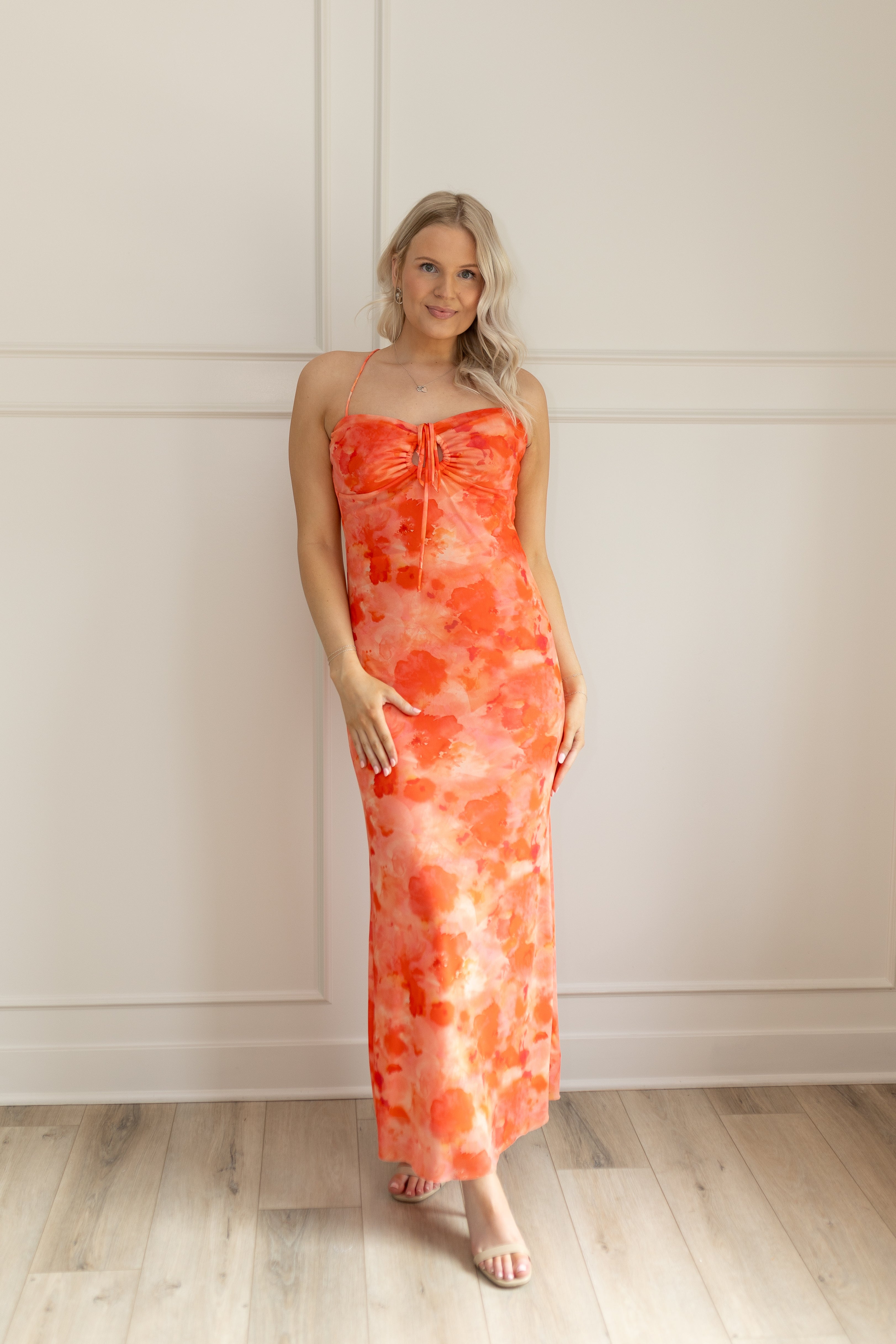 Orange mesh floral mini dress with adjustable spaghetti straps and keyhole cutout. 