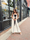 Woman in cream knit maxi dress with black piping and detachable black bandeau top