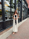 Woman in cream knit maxi dress with black piping and detachable black bandeau top