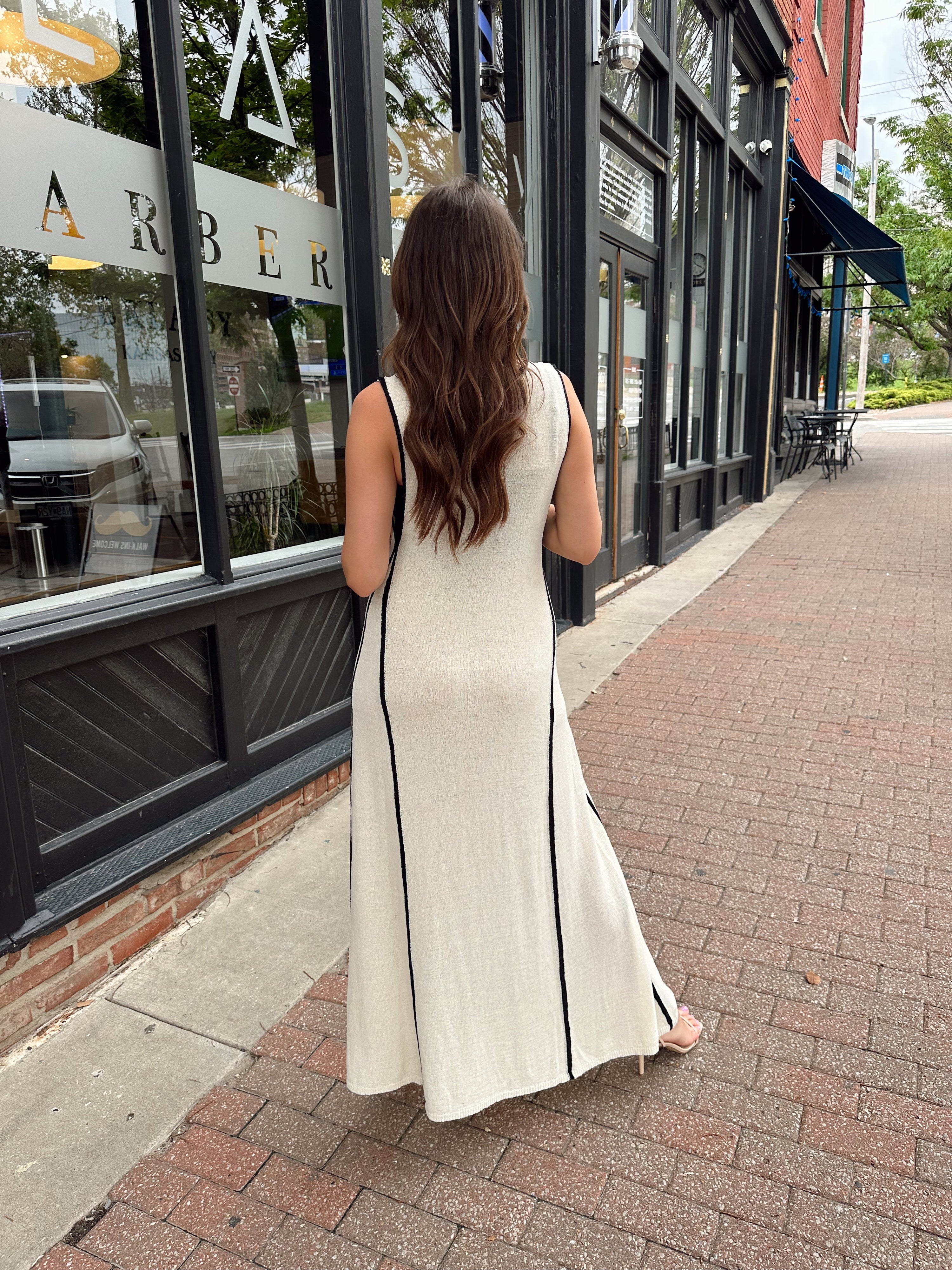Woman in cream knit maxi dress with black piping and detachable black bandeau top