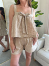 Woman wearing taupe gingham two piece set with bow tie top and shorts